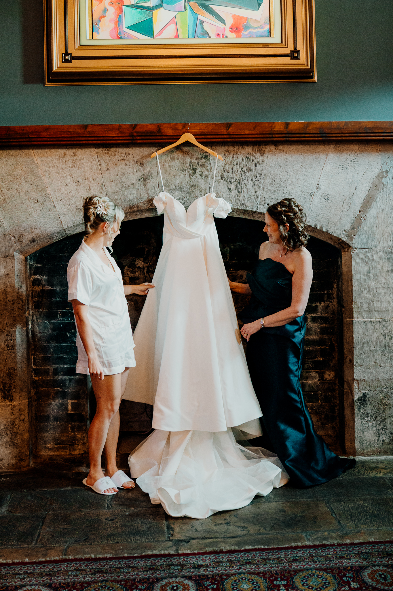 Bride and bridesmaids admiring the wedding dress hanging in the Gin Bar at Markree Castle.