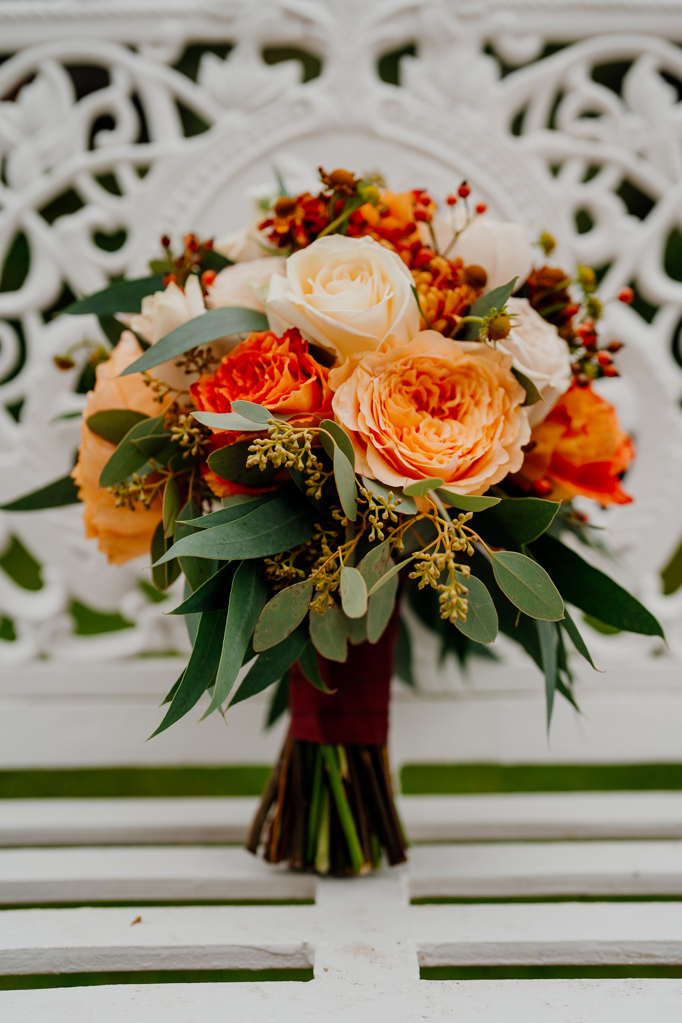 Autumn bridal bouquet with peach roses, orange flowers and greenery by The Flower Shed at Markree Castle.