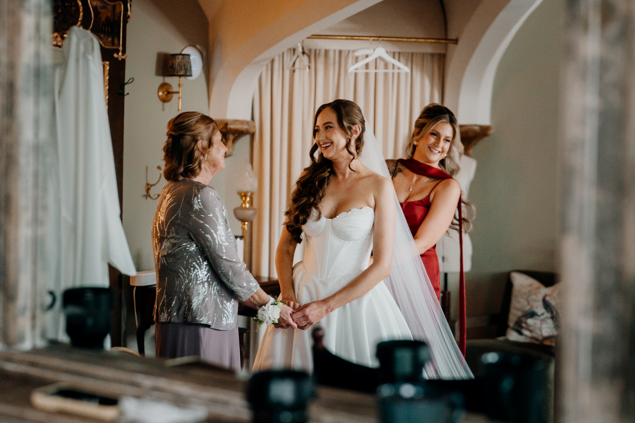 Bride having her wedding dress adjusted by bridesmaids during morning preparations at Markree Castle.