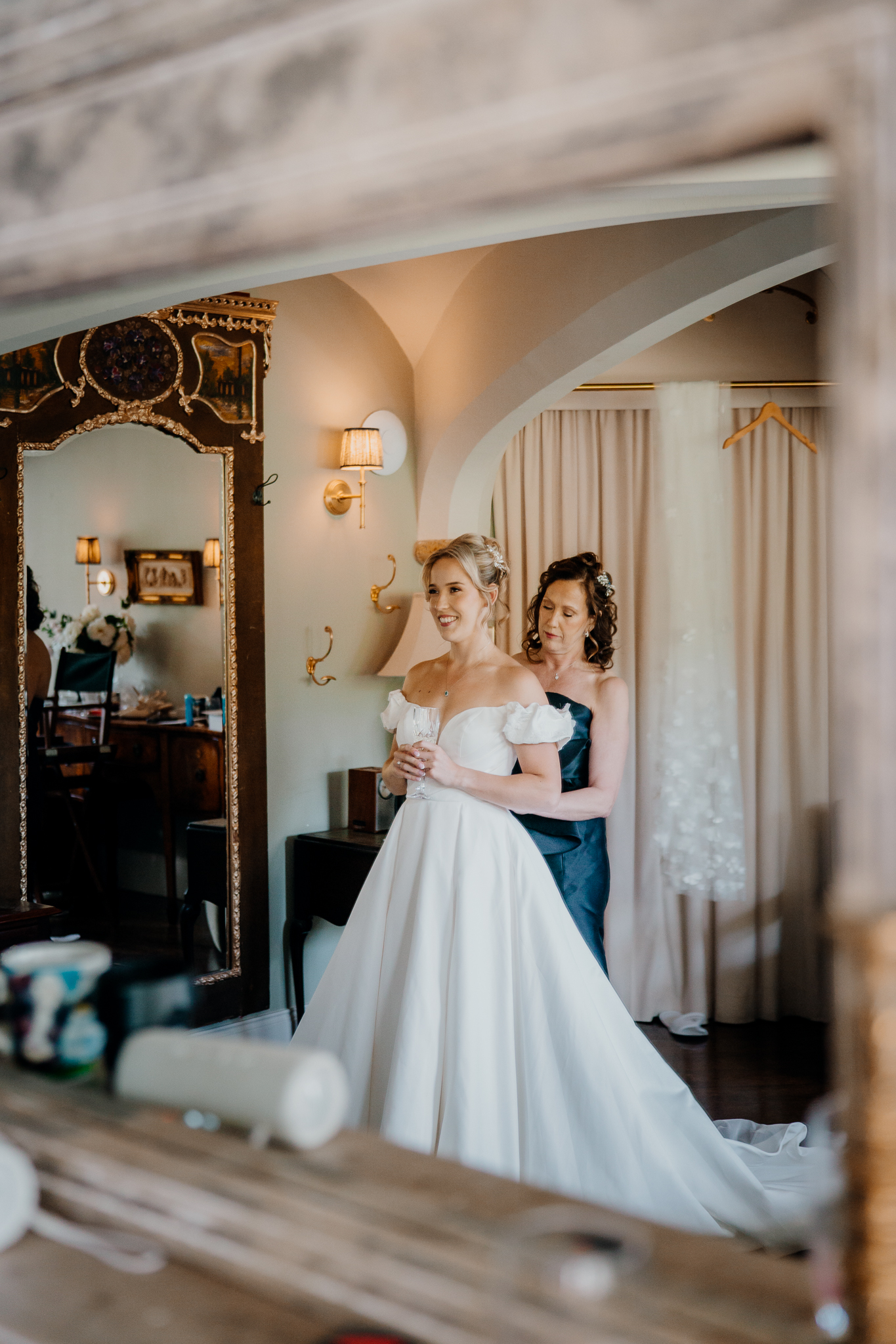 Mother helping the bride fasten her wedding dress in the Bridal Suite at Markree Castle, County Sligo.
