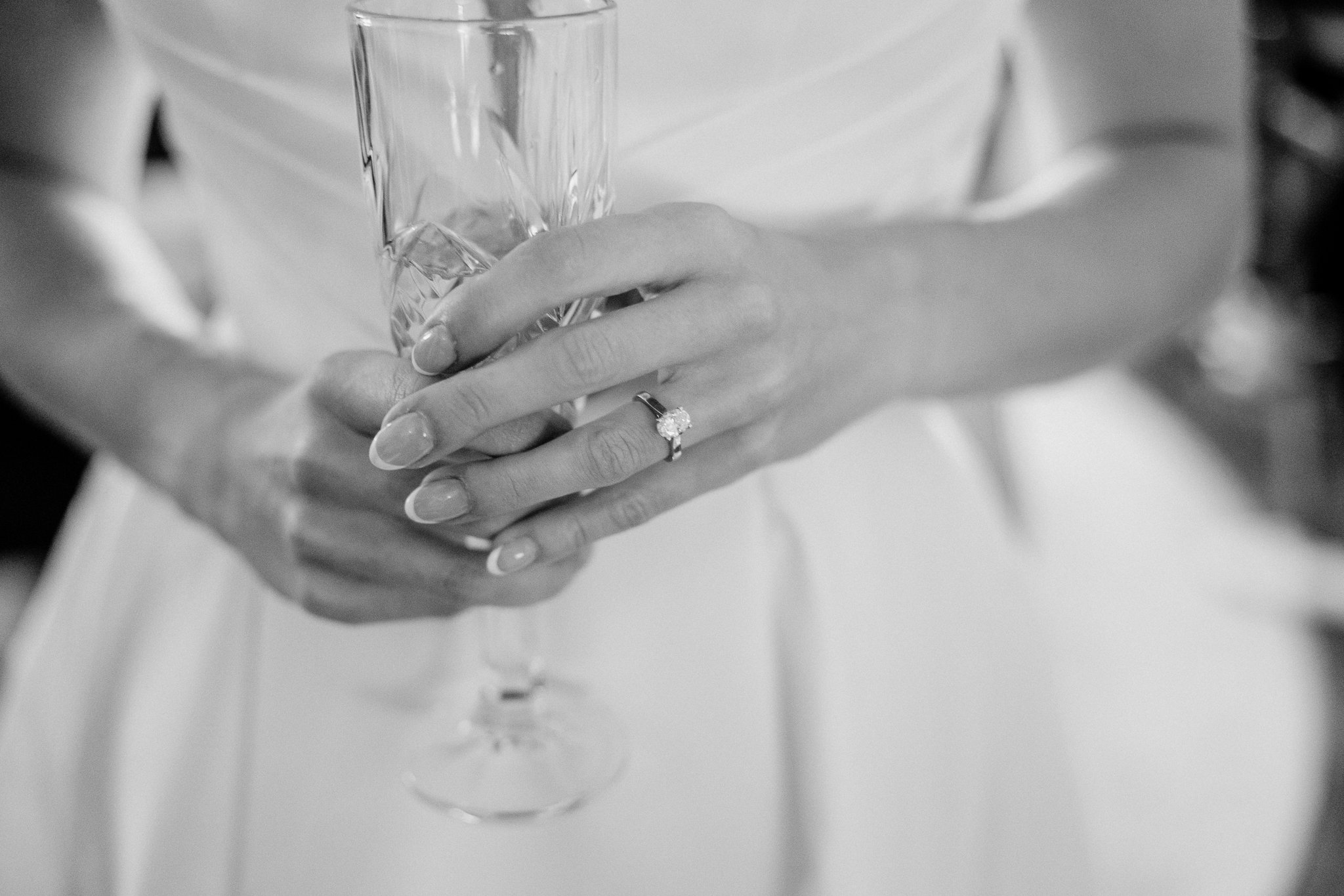 Black and white close-up of a mother's hands fastening her daughter's wedding gown at Markree Castle.