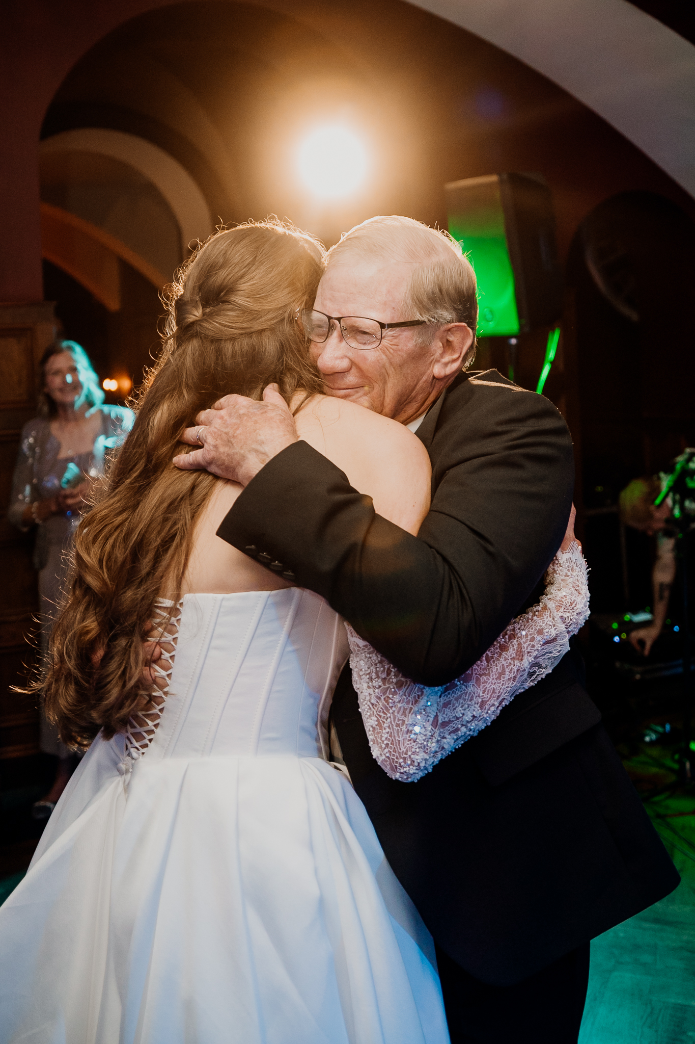 Bride sharing a warm embrace with an older male guest on the evening wedding dance floor at Markree Castle.