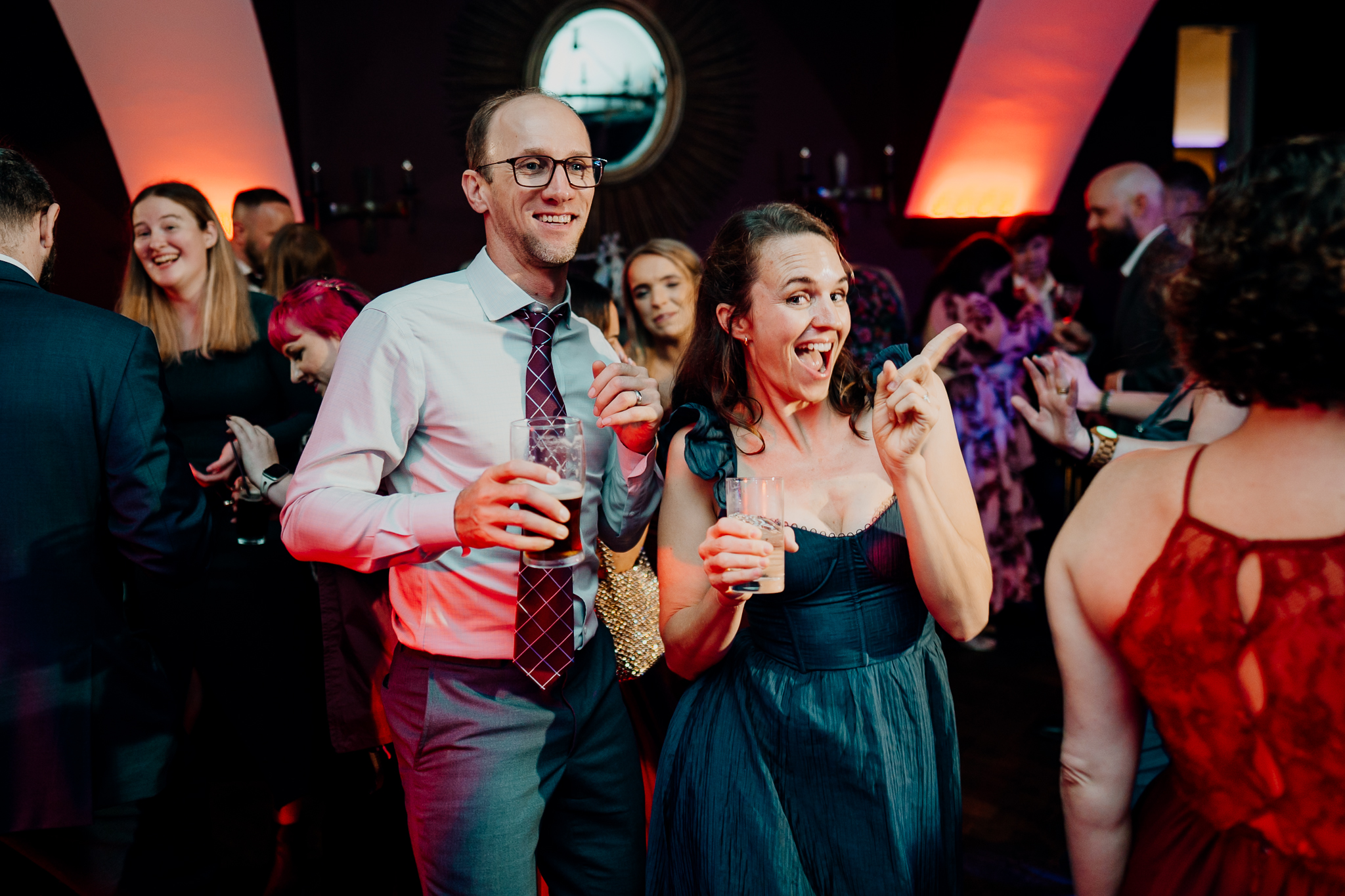 Wedding guests dancing together beneath colourful evening party lights inside Markree Castle.