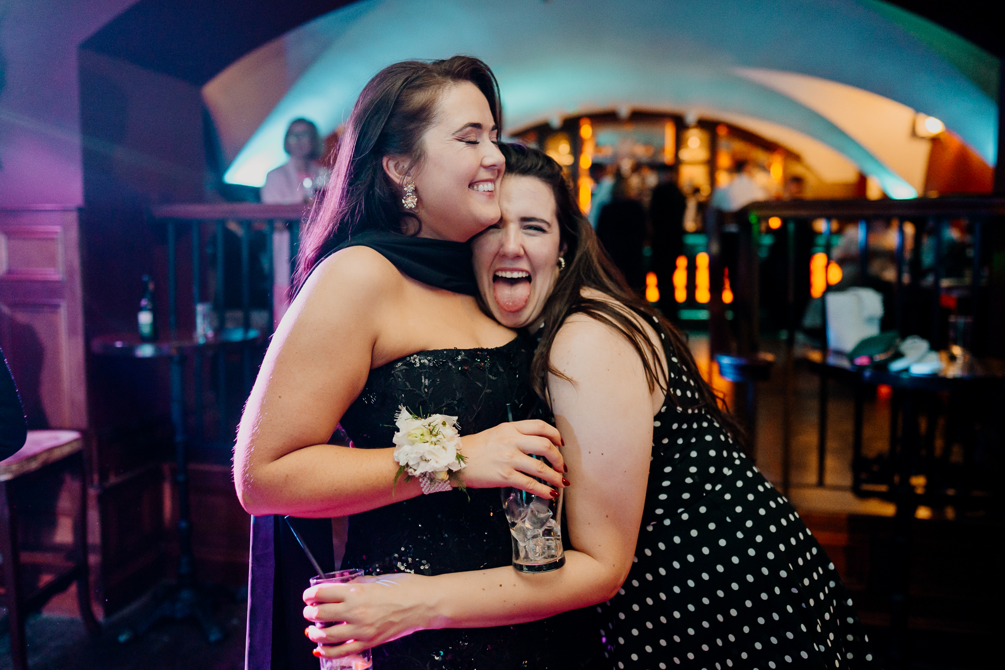 Two female wedding guests sharing a joyful embrace on the dance floor during an evening celebration at Markree Castle.