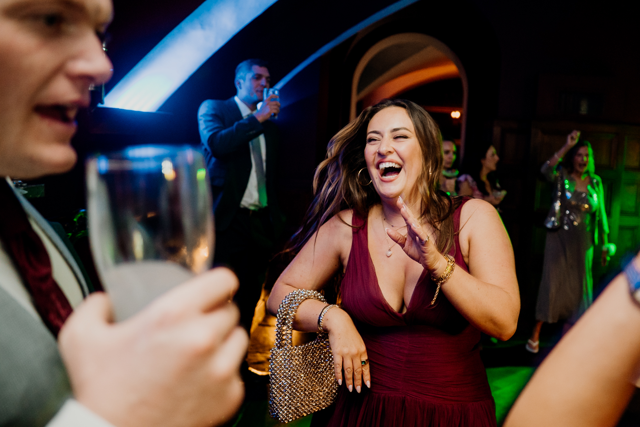 Female wedding guest singing along beneath blue party lights with live entertainment in the background at Markree Castle.