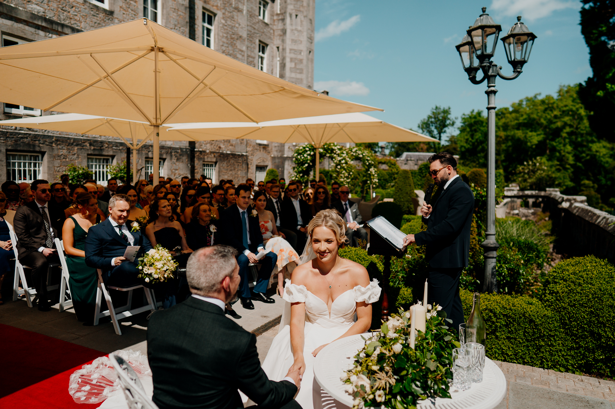 Garden terrace wedding ceremony setup with cream parasols and seated guests at Markree Castle.