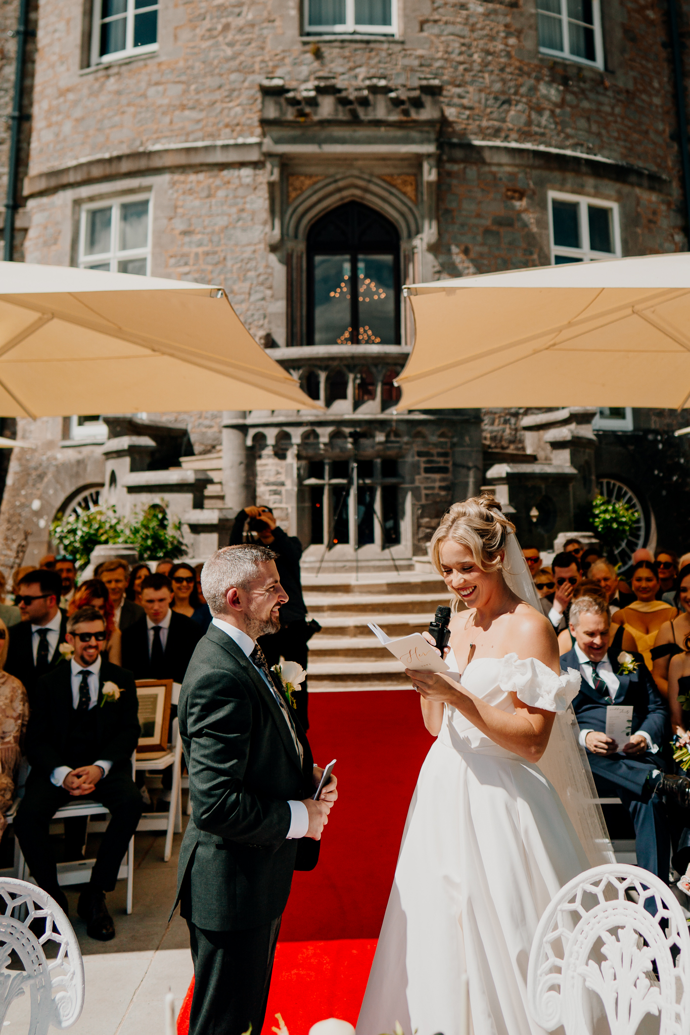 Bride in a white wedding dress at an outdoor garden ceremony beneath parasols at Markree Castle.