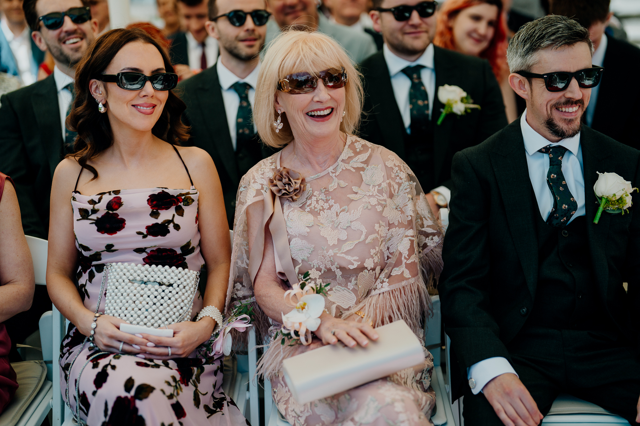 Wedding guest in a lace dress and sunglasses attending a garden ceremony at Markree Castle.