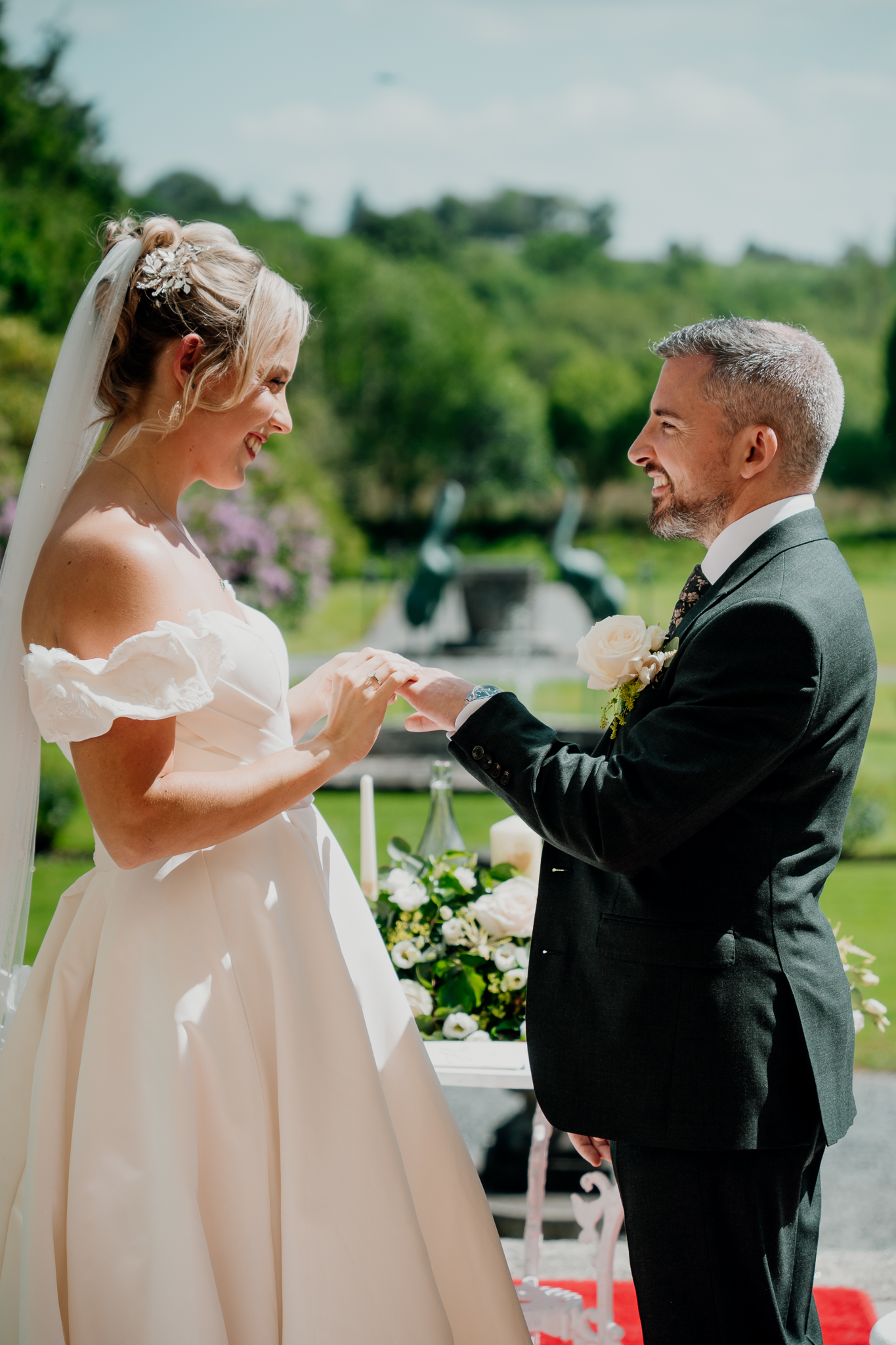 Bride and groom facing each other during their garden terrace wedding ceremony at Markree Castle.