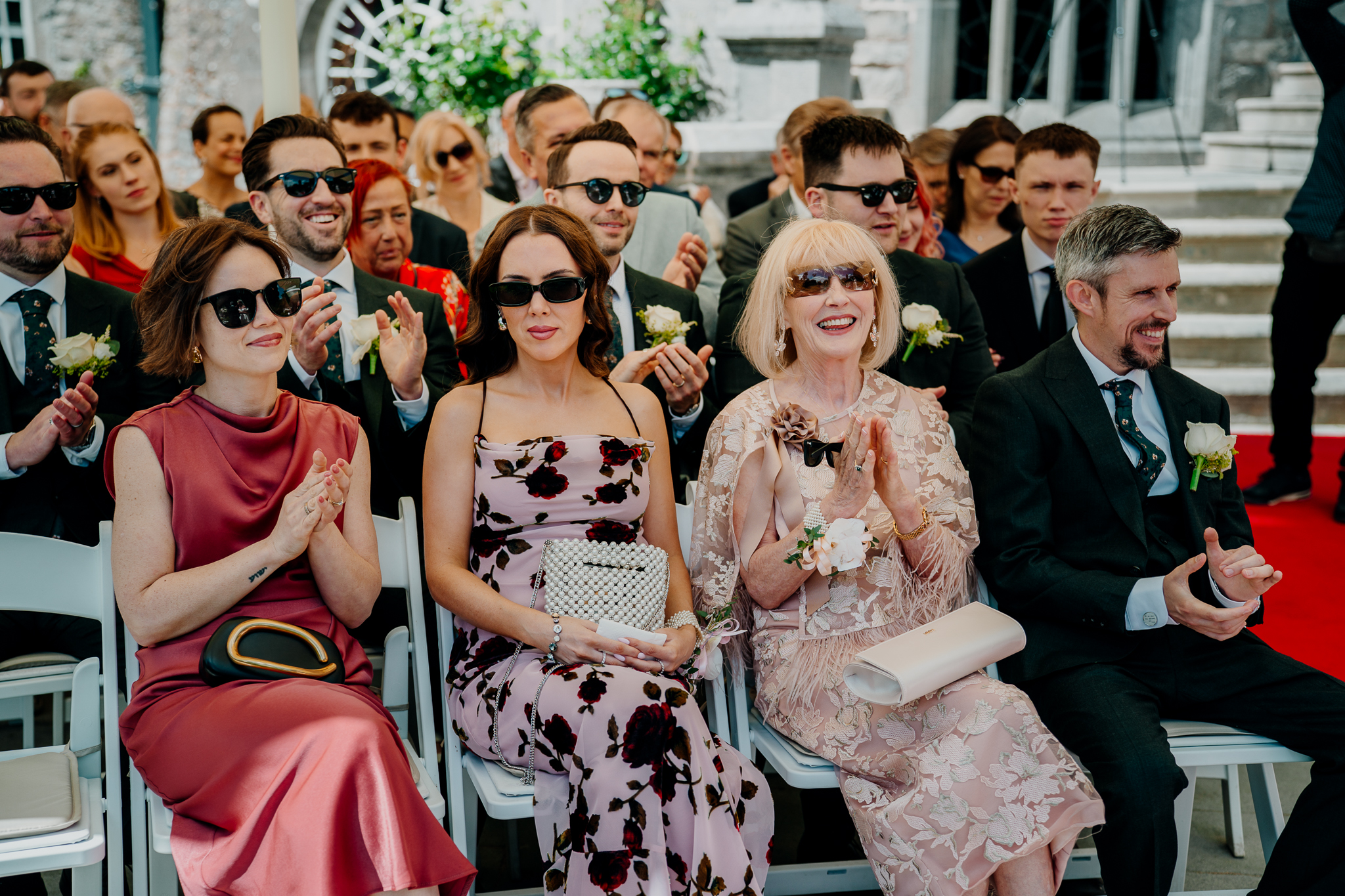 Wedding guests smiling and watching the outdoor garden ceremony at Markree Castle.