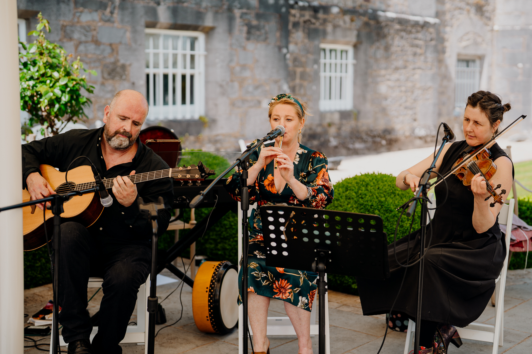 Two live musicians performing outdoors during a wedding drinks reception in the gardens of Markree Castle, Sligo.
