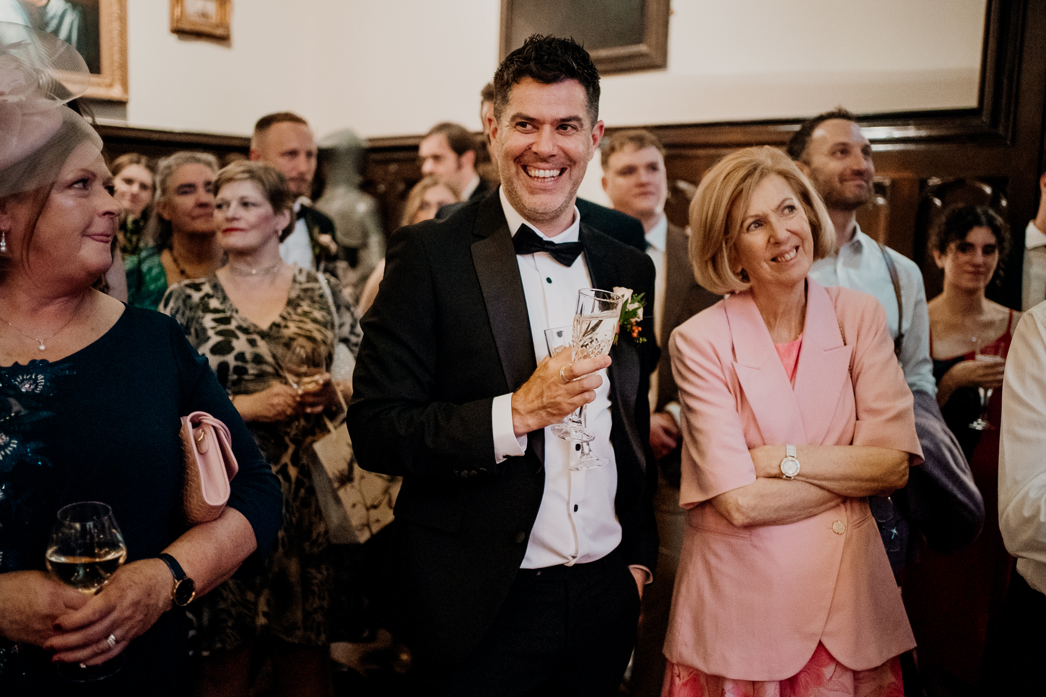 Groom in a dark green suit laughing with wedding guests during speeches at Markree Castle.