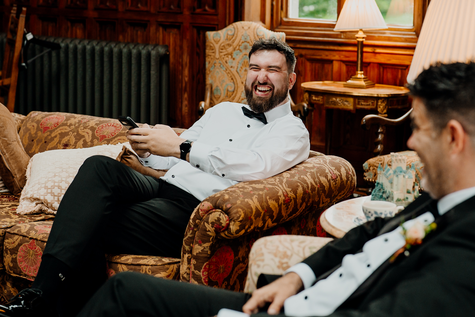 Groom smiling while adjusting his shirt cuffs during wedding morning preparations at Markree Castle.