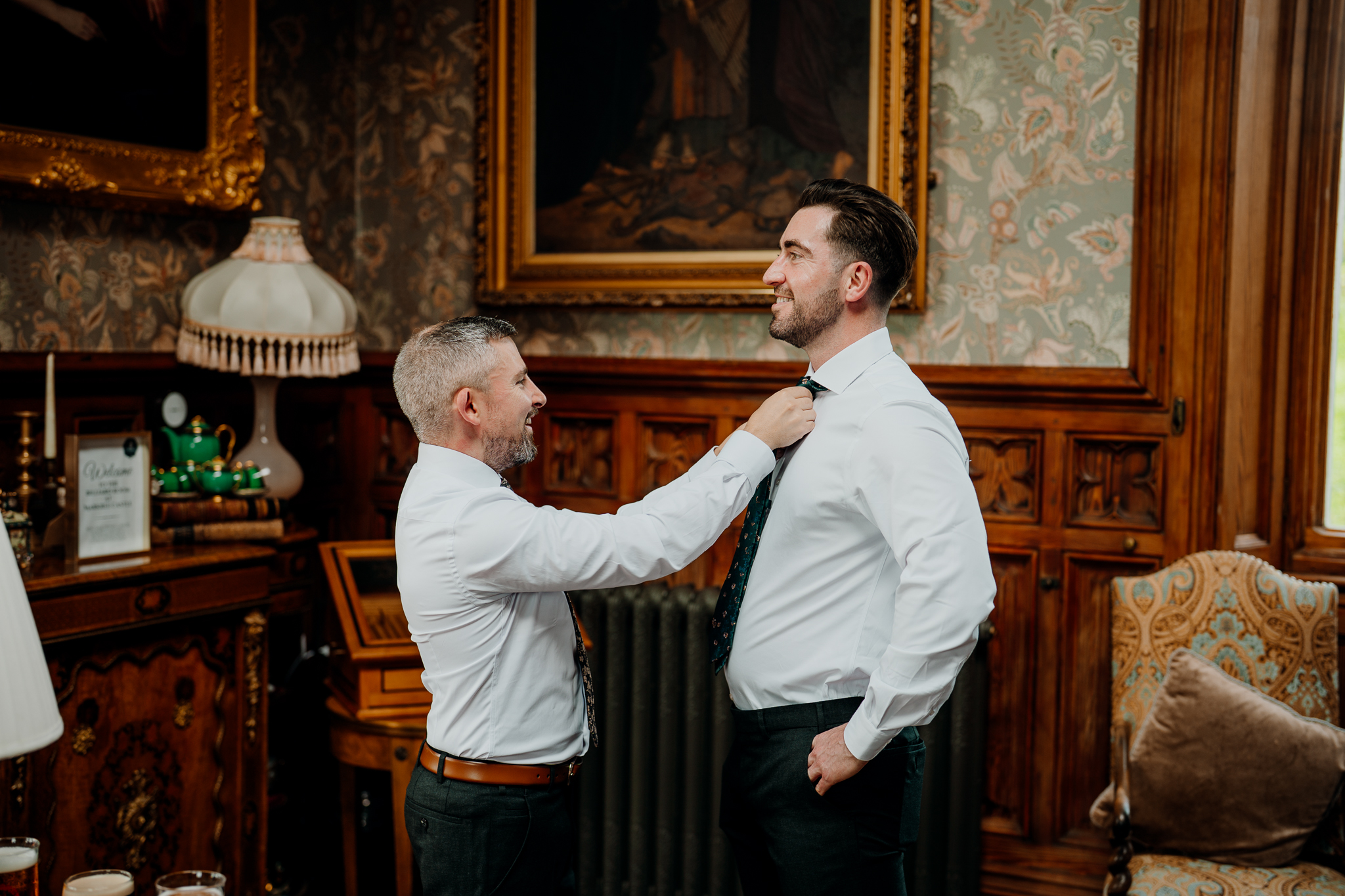 Groom having his collar adjusted during wedding preparations in the historic Billiard Room at Markree Castle.