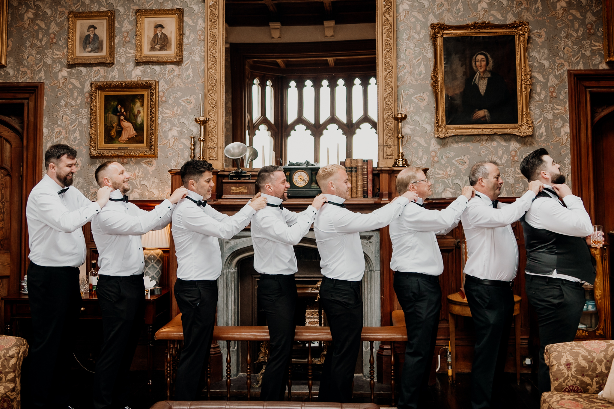 Groom and groomsmen standing together with their arms around each other in the historic Billiard Room at Markree Castle.