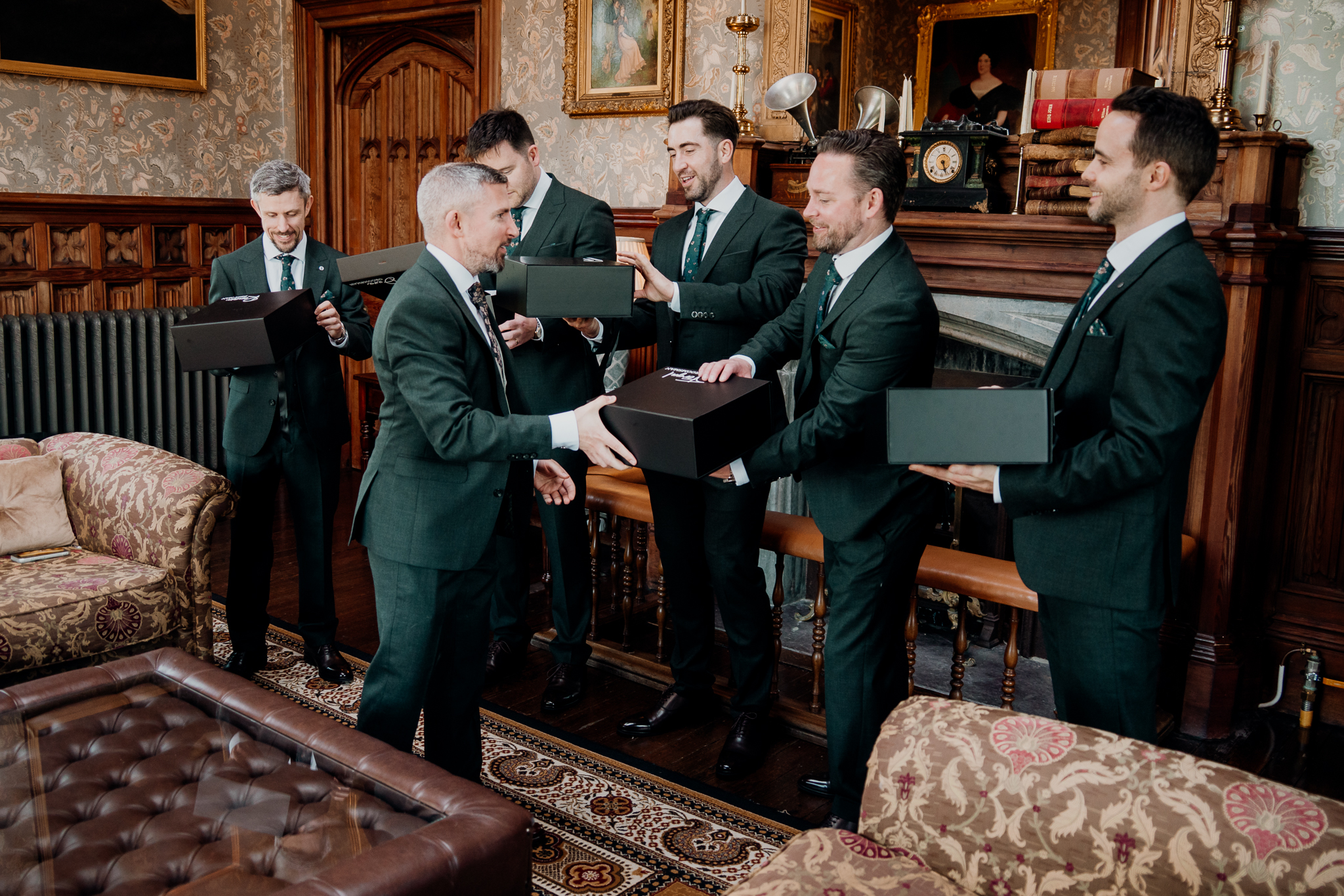 Groom presenting gifts to his groomsmen during wedding preparations in the Billiard Room at Markree Castle.