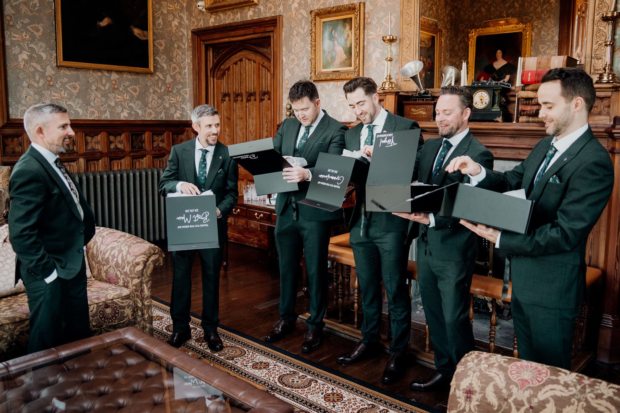 Groomsmen opening wedding party gifts together in the Billiard Room at Markree Castle, County Sligo.