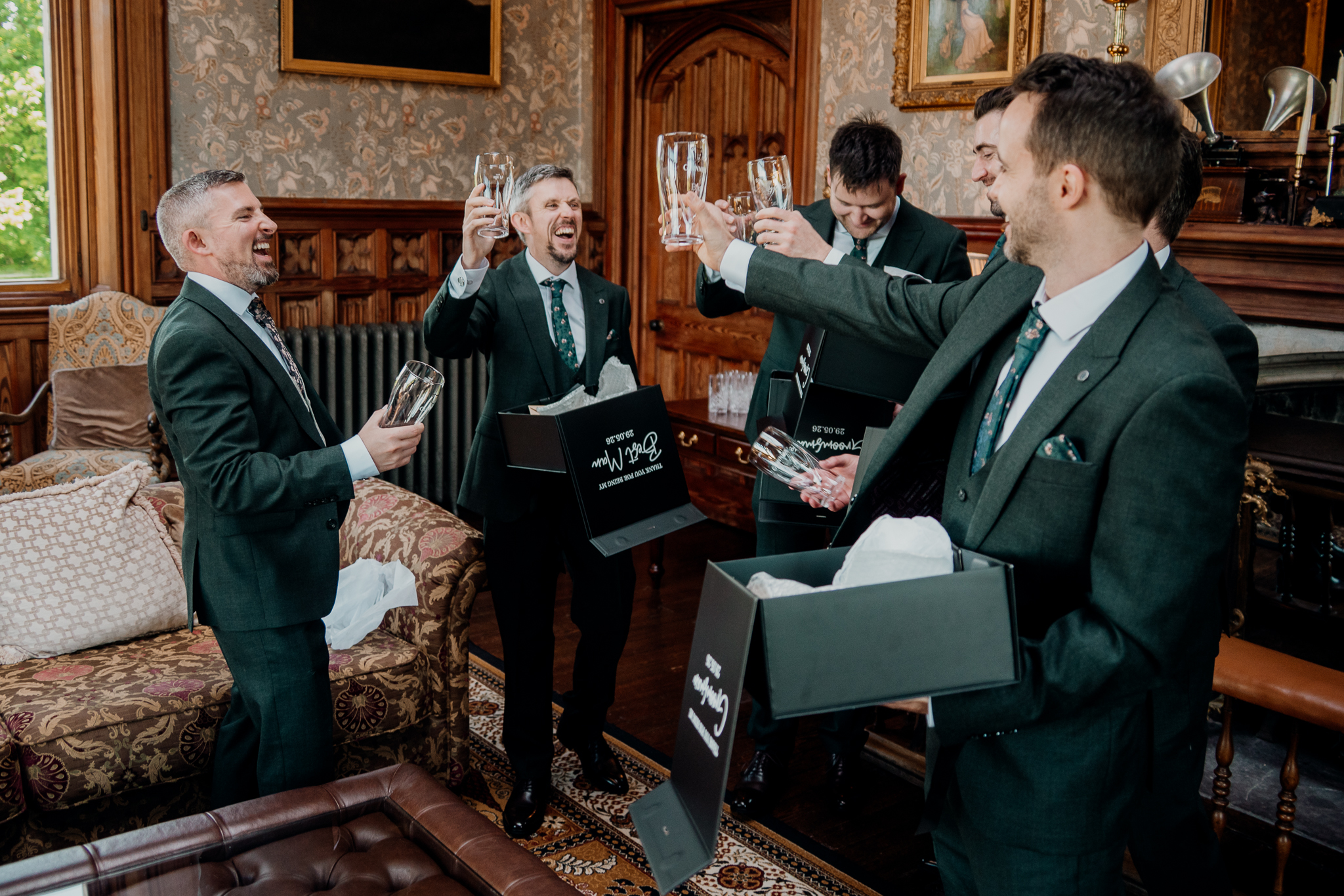 Groom and groomsmen sharing reactions while exchanging gifts in the Billiard Room at Markree Castle.