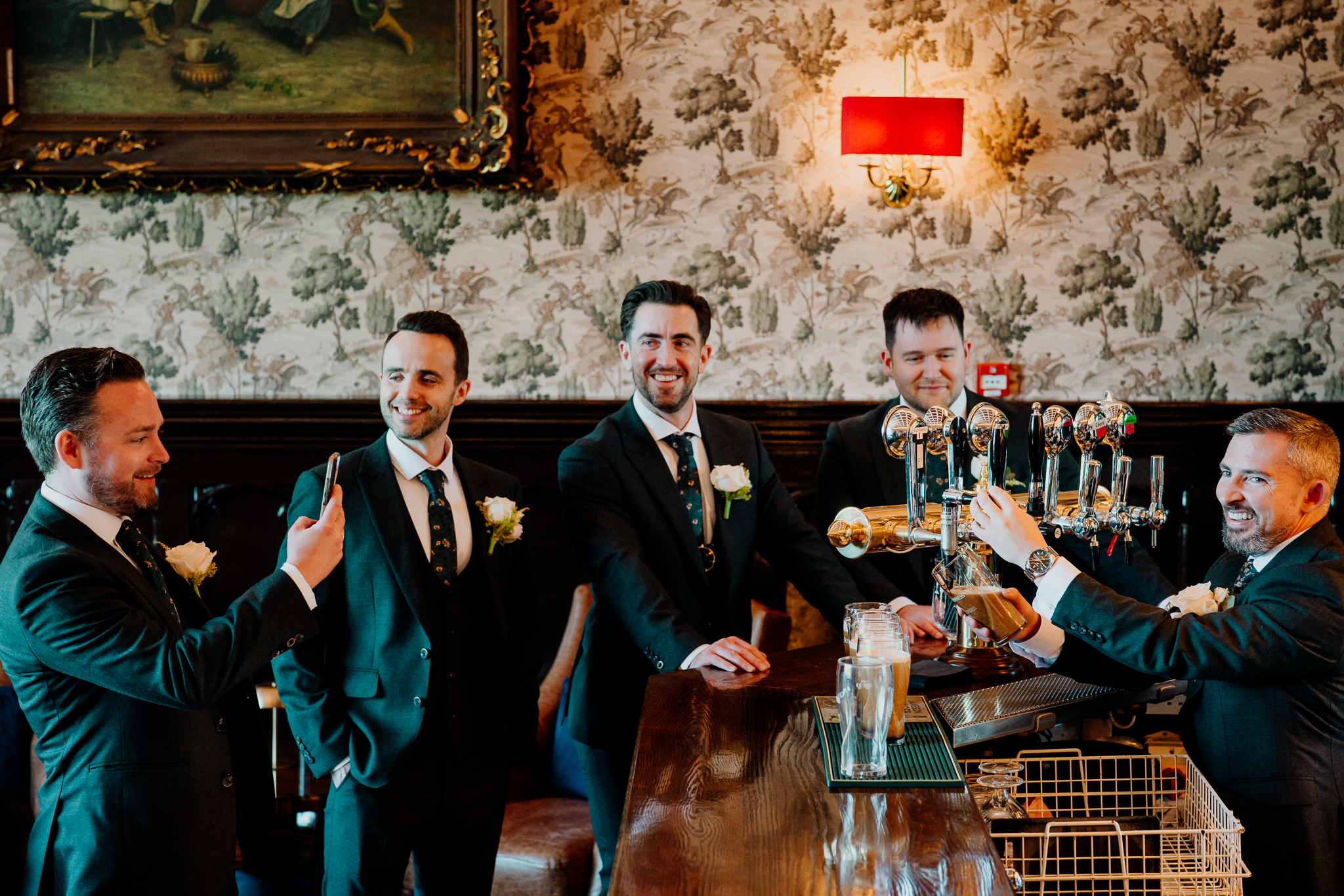 Groom and groomsmen raising a toast in the historic Billiard Room at Markree Castle, County Sligo.