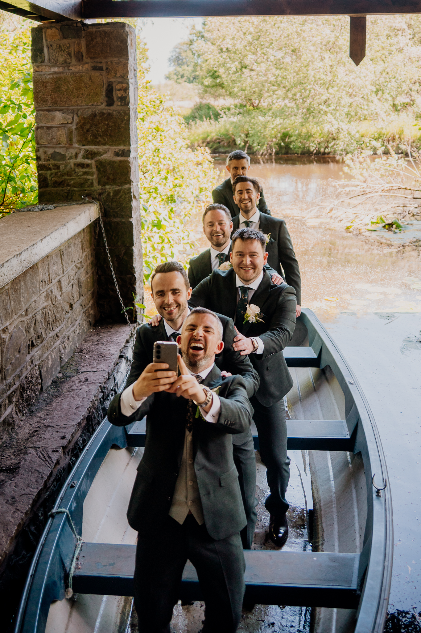 Groom and groomsmen posing together by the stone steps near the Boathouse at Markree Castle.