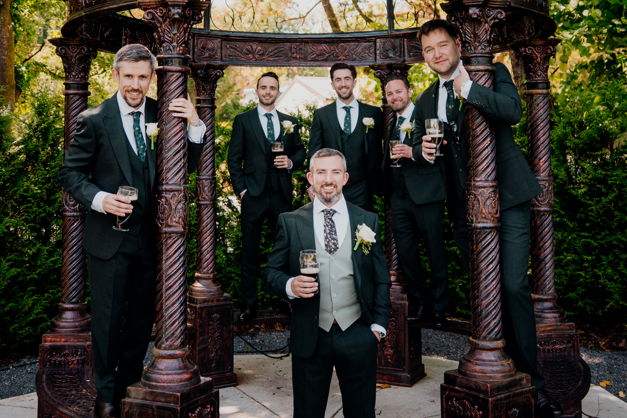Black and white group portrait of groom and groomsmen beneath a tree in the gardens of Markree Castle.