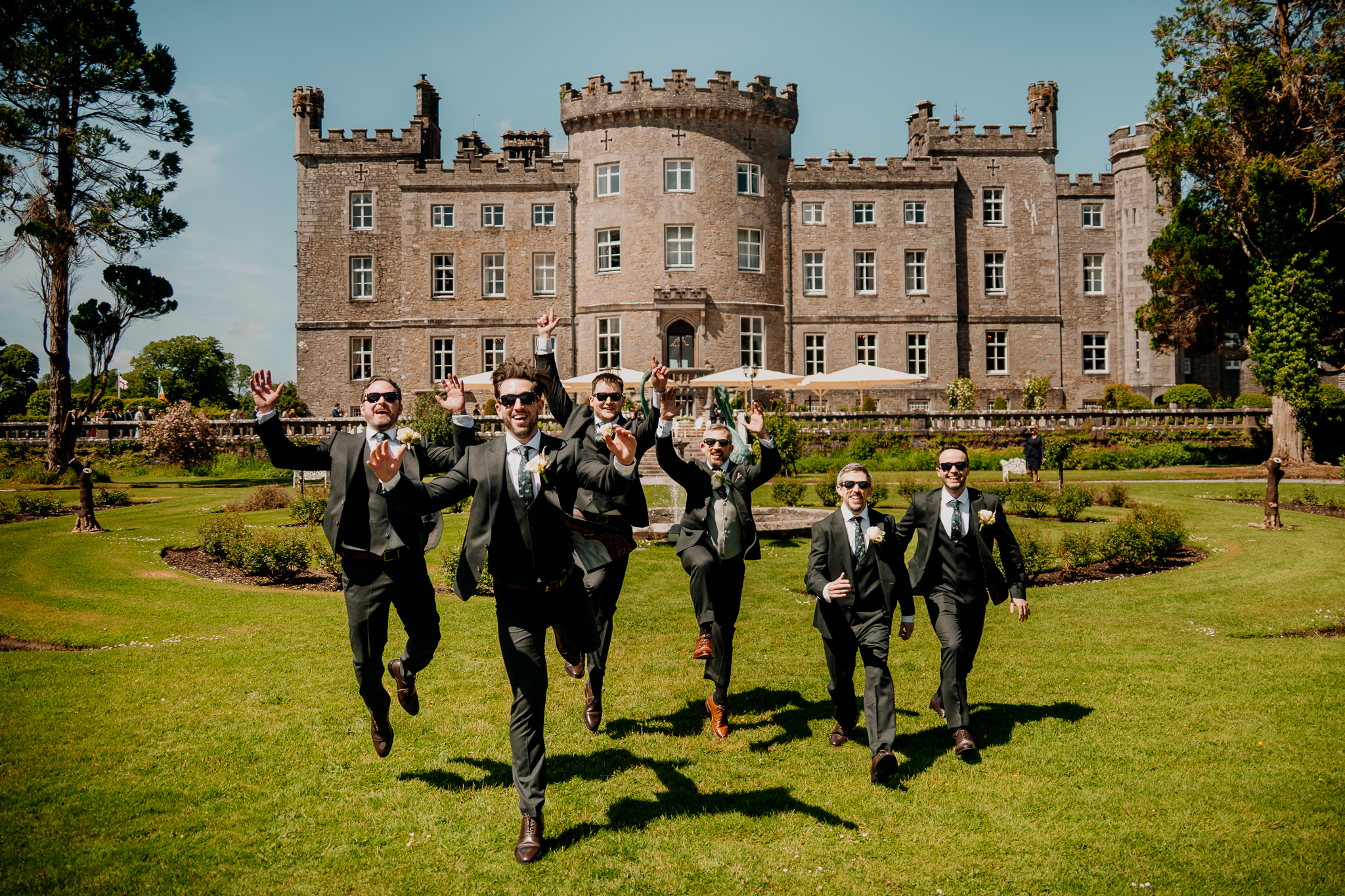 Groom and groomsmen walking towards the Boathouse with Markree Castle visible in the background.
