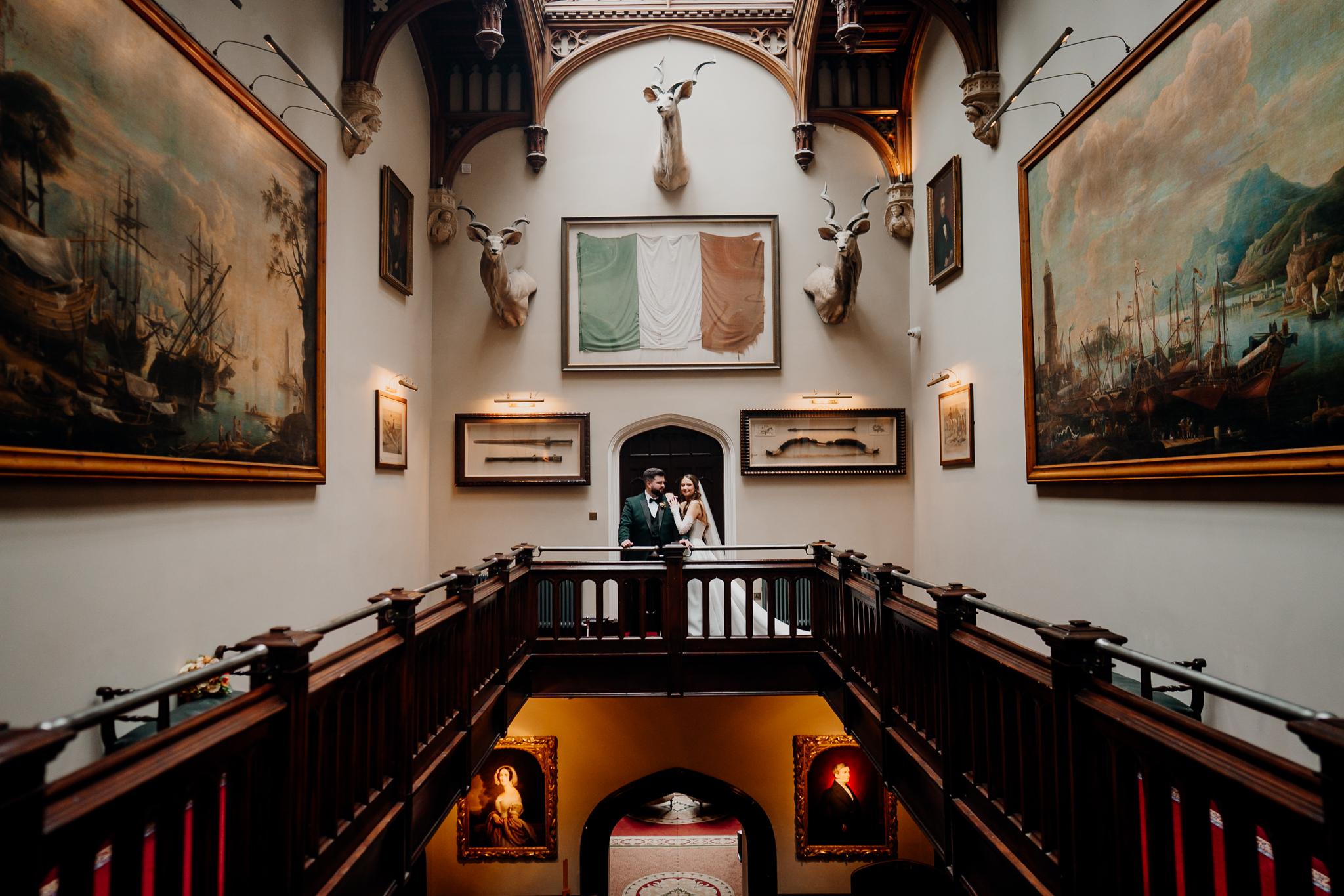 Historic gallery balcony interior at Markree Castle featuring framed paintings, ornate furnishings and warm natural light.