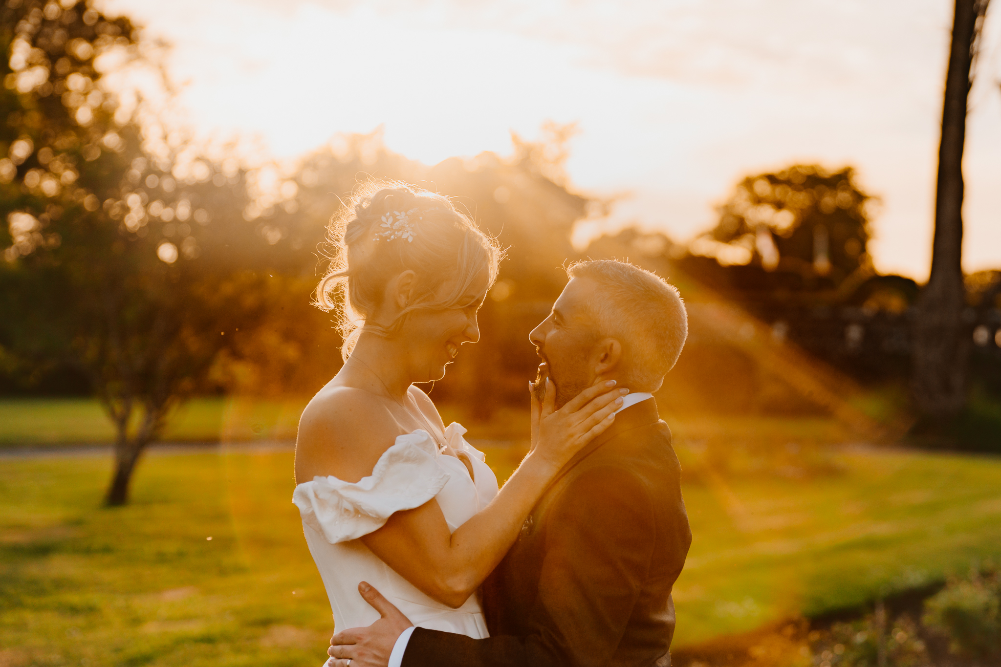 Close-up of bride Zoe and groom Mark facing each other in warm backlit sunset light during their Markree Castle wedding.