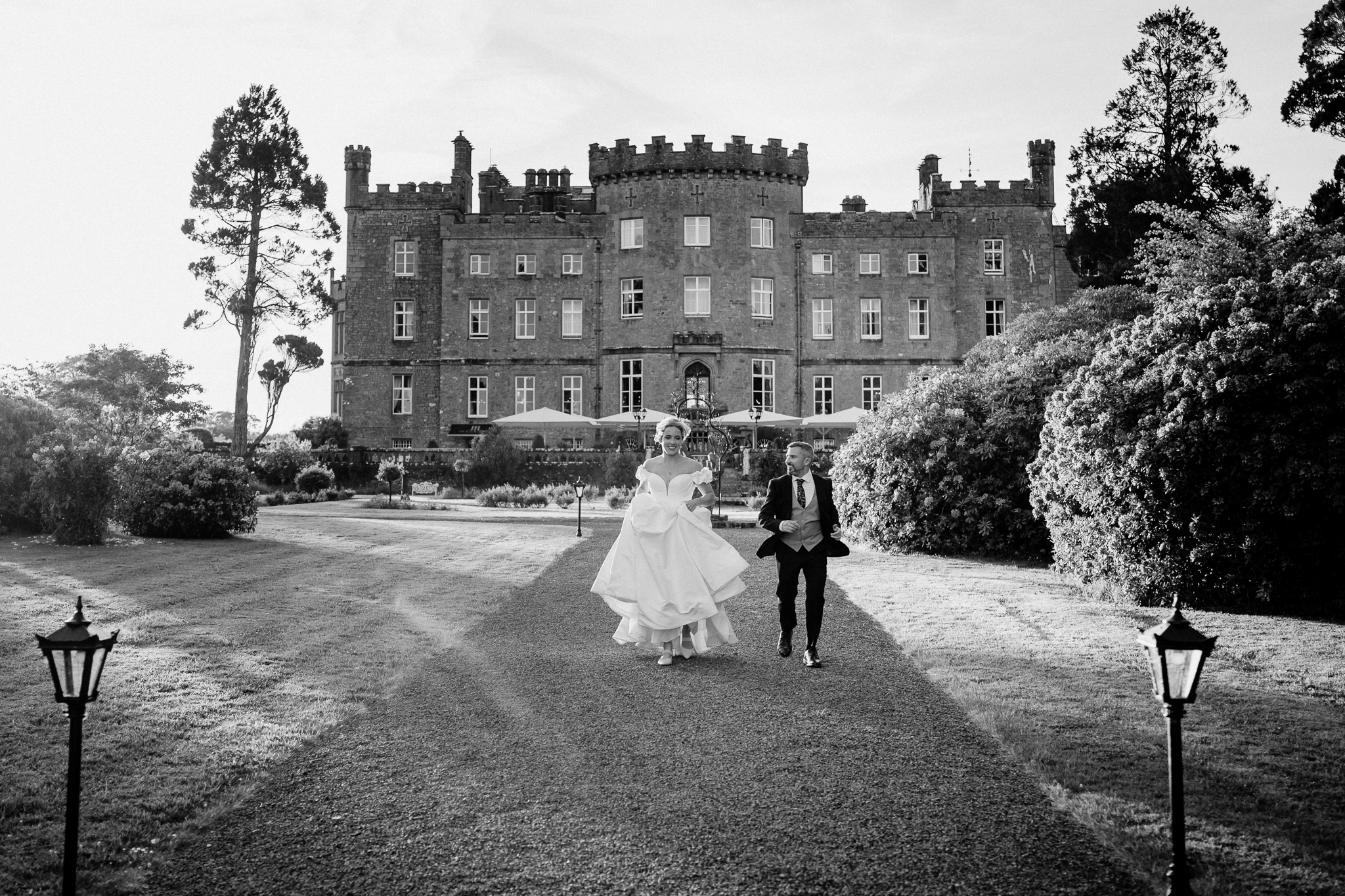 Black and white wedding portrait of bride and groom in front of the historic Markree Castle facade in County Sligo.
