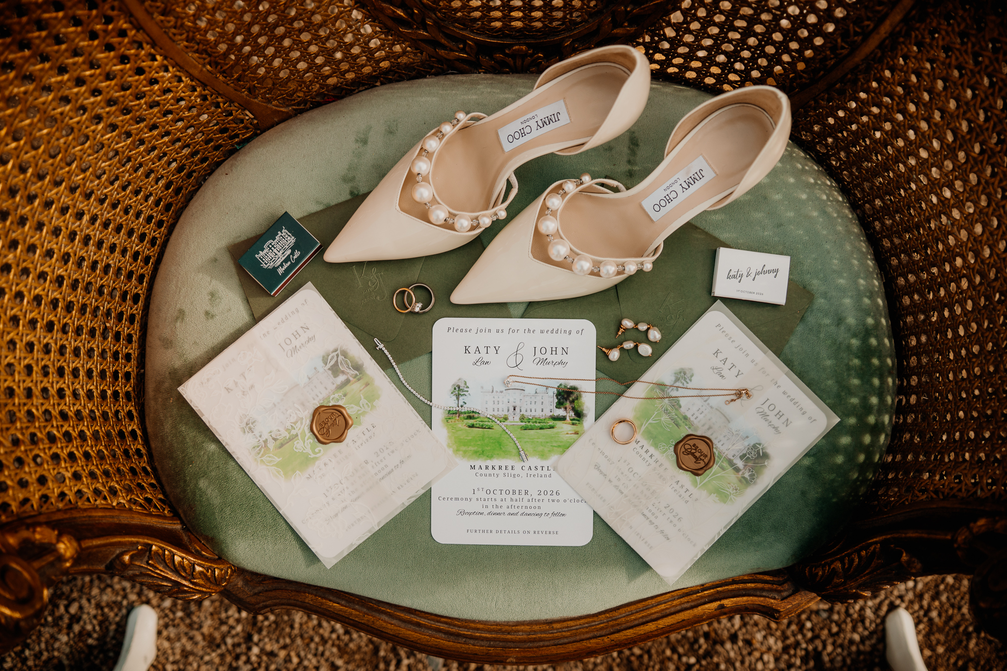 Jimmy Choo bridal shoes, Markree Castle wedding invitations, rings and jewellery arranged on a vintage green chair.