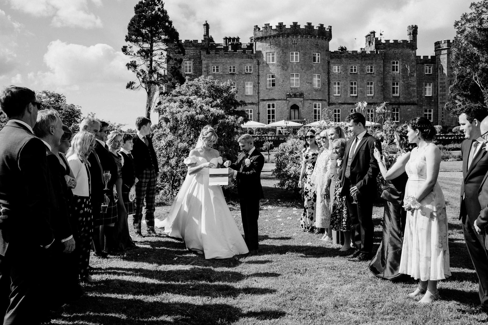 Black and white photograph of wedding guests gathered in the gardens of Markree Castle during a butterfly release.