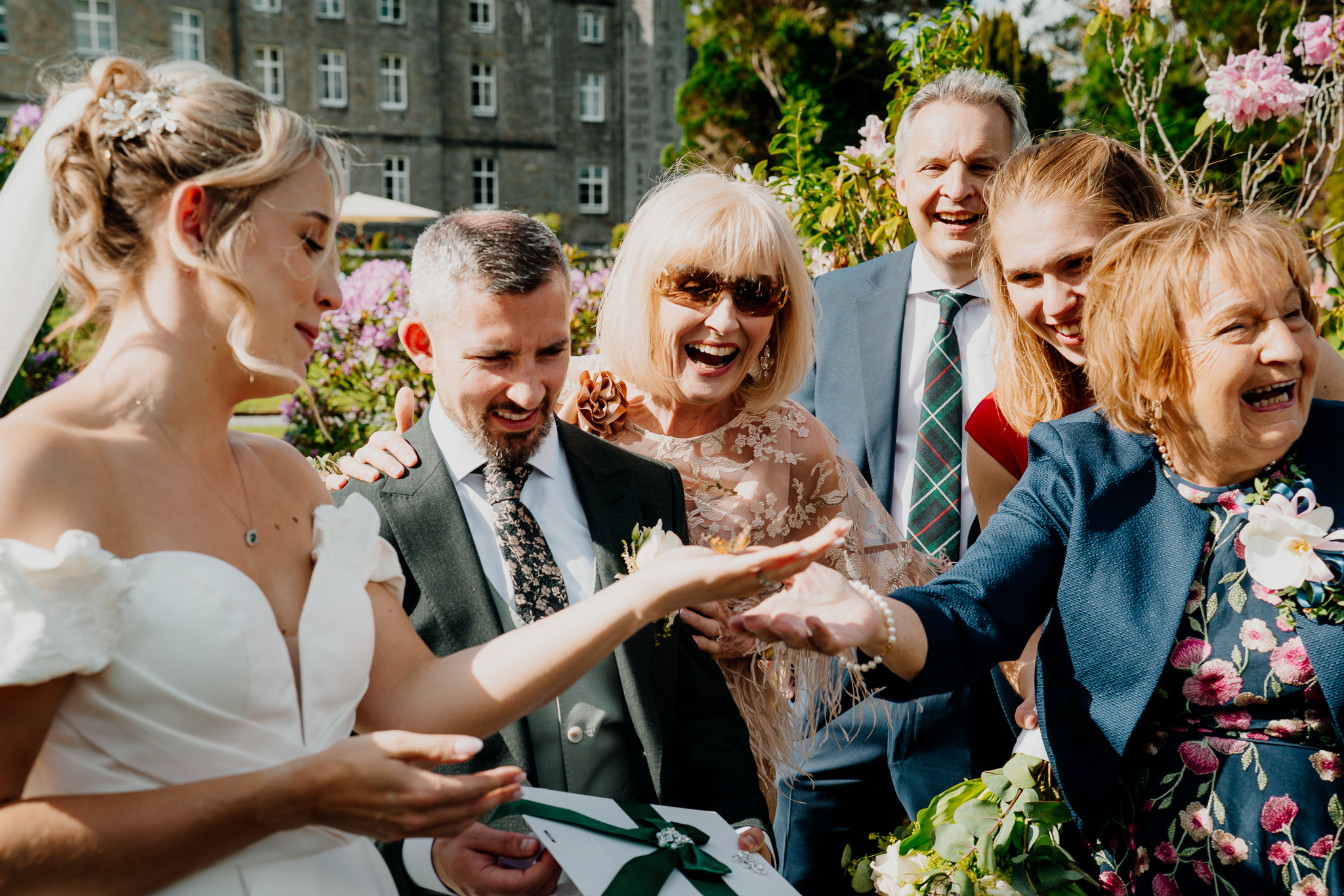 Wedding guests smiling and reacting together during Zoe and Mark's butterfly release in the gardens of Markree Castle.