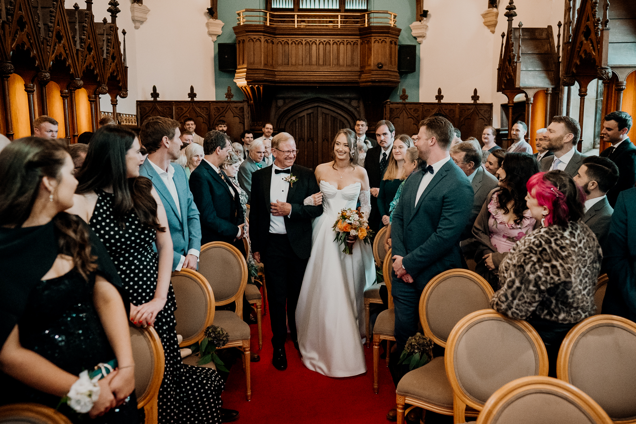 Bride walking down the aisle with her father as wedding guests watch inside Markree Castle Chapel.