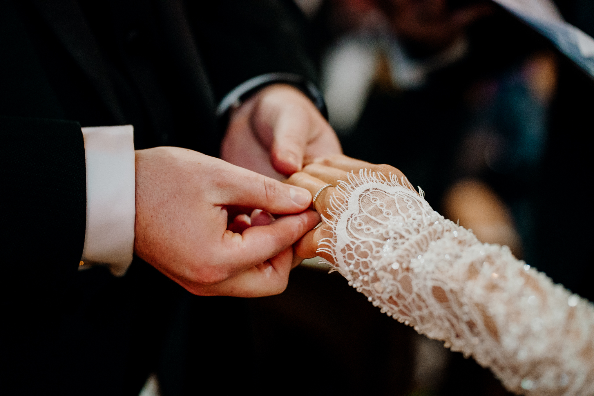 Close-up of groom Anthony placing a wedding ring on bride Amy's finger during their ceremony at Markree Castle Chapel.