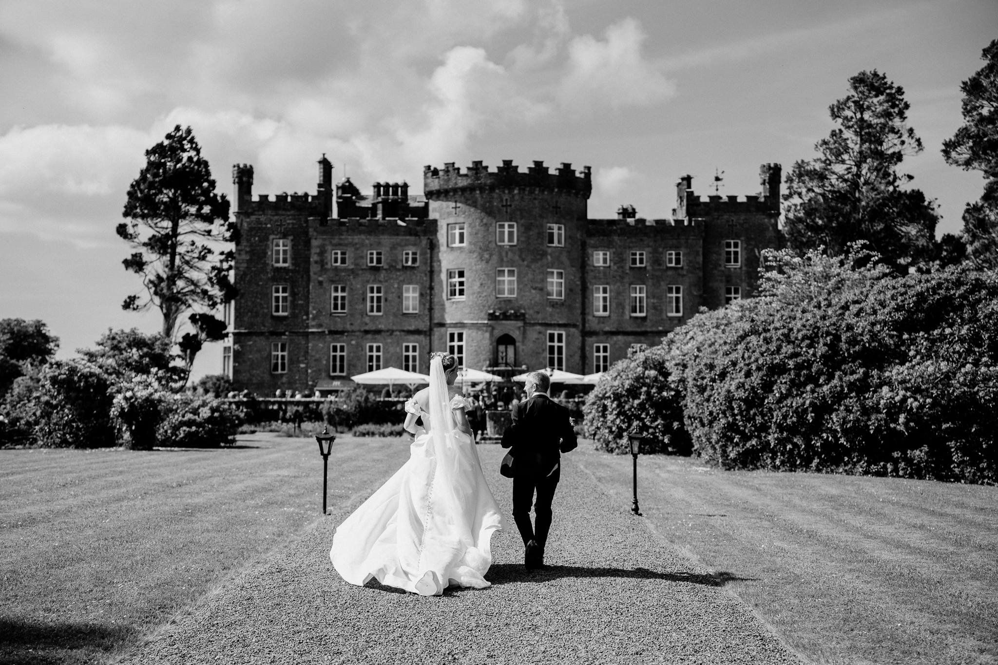 Black and white wedding portrait of a bride and groom in the gardens with Markree Castle behind them.