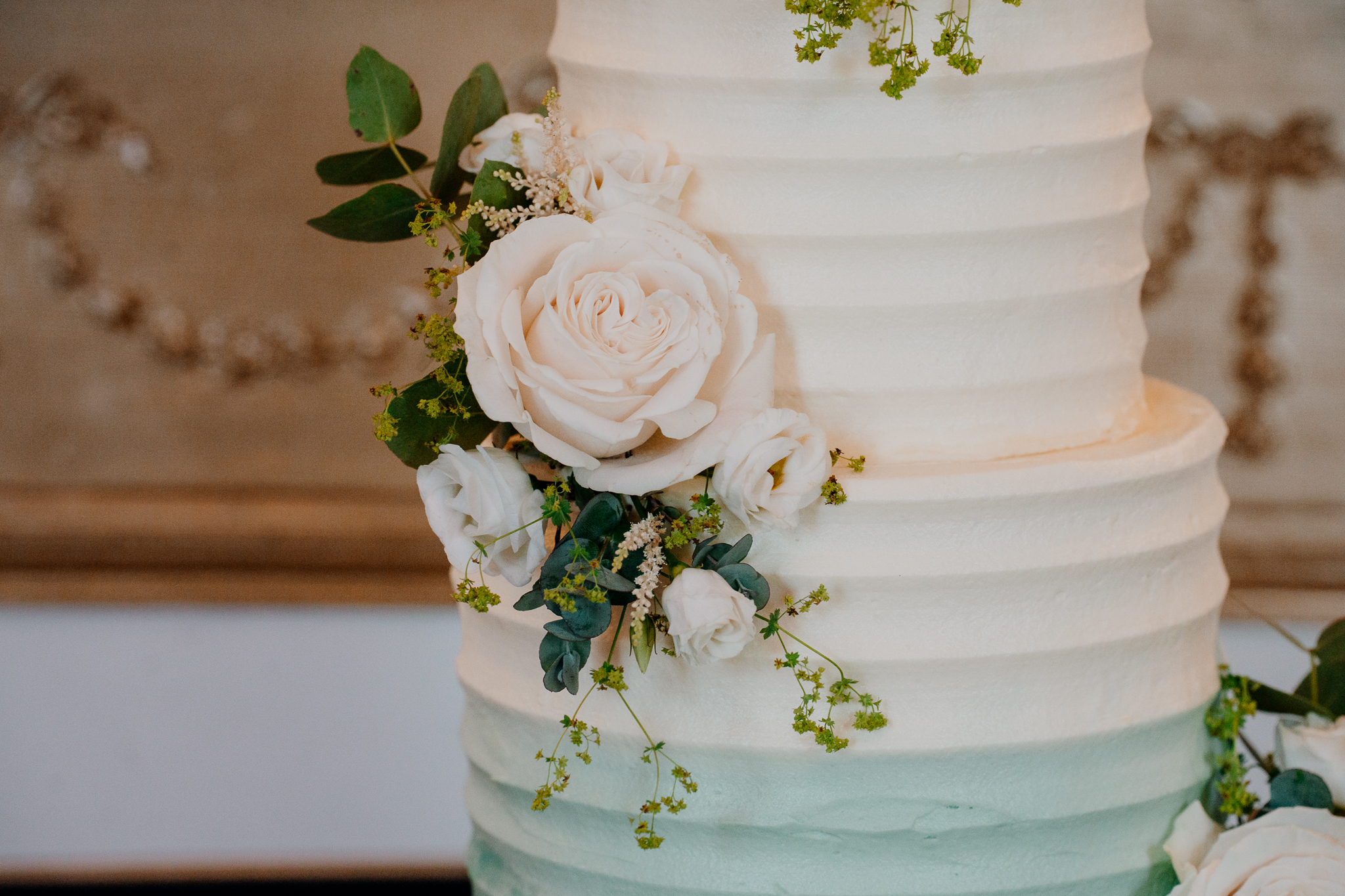 Close-up of a white rose and greenery decorating a wedding cake at Markree Castle.