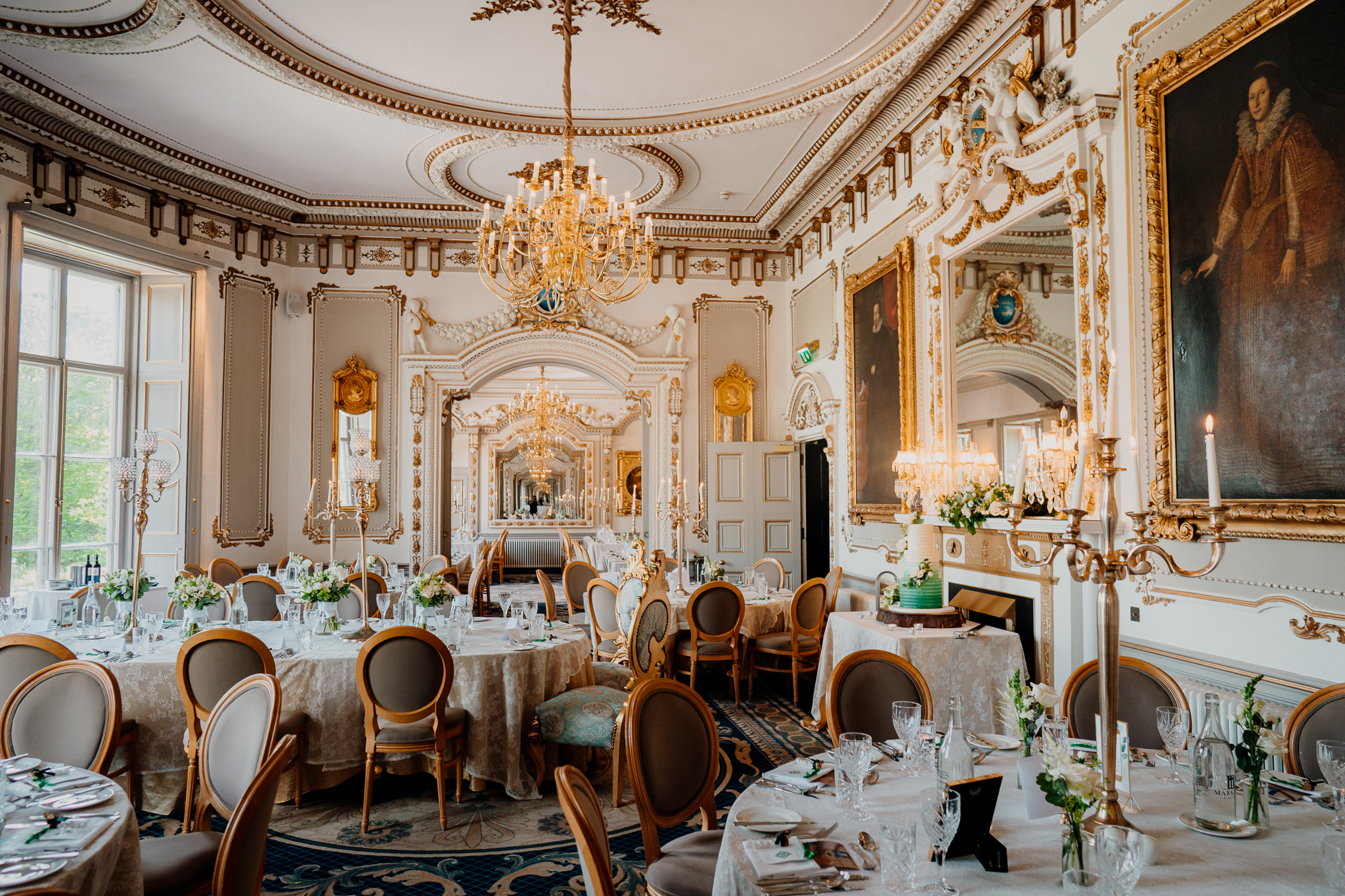 Elegant Markree Castle wedding dining room with ornate ceilings, chandeliers and tables prepared for a wedding reception.