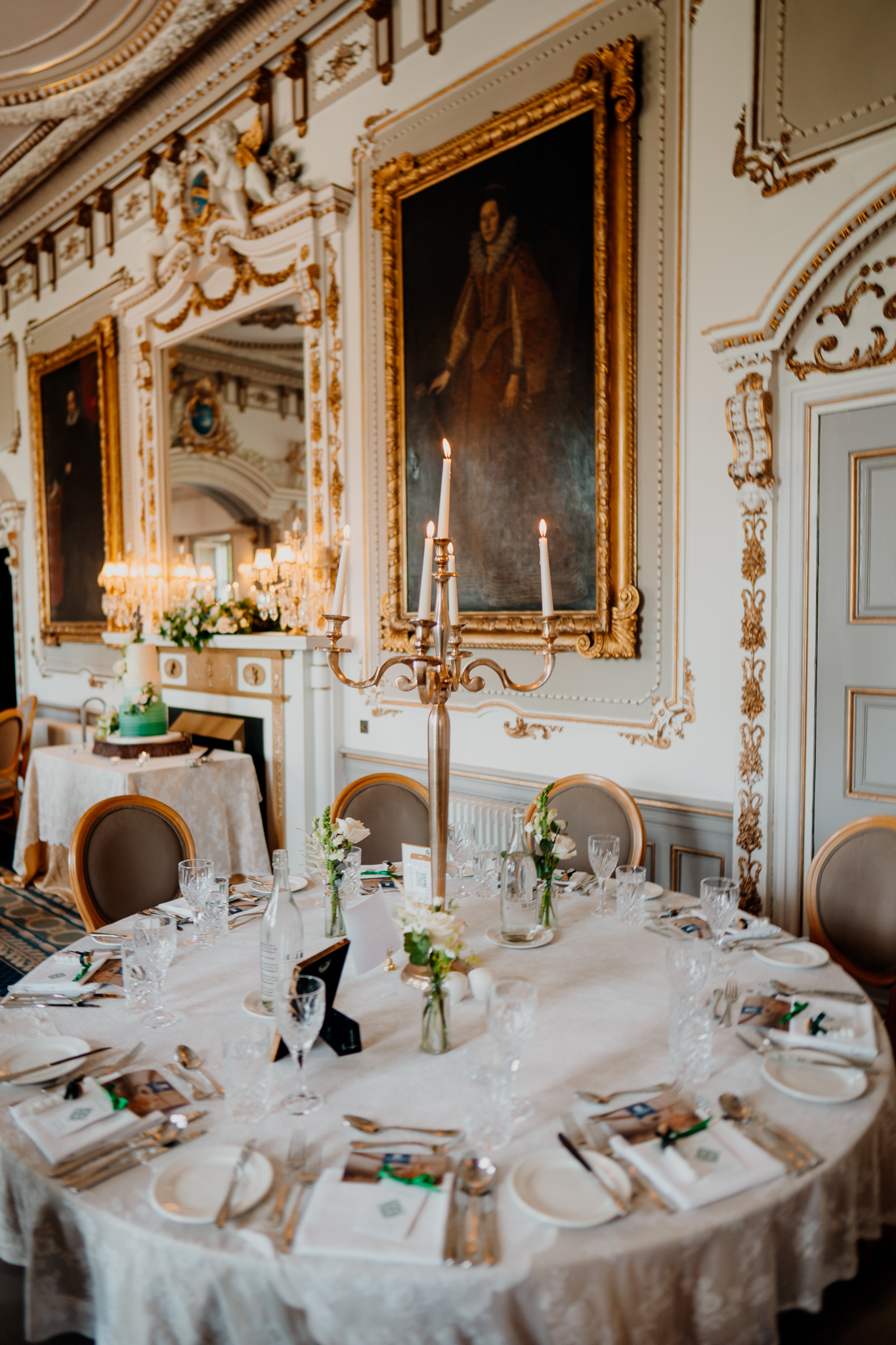 Ornate dining room interior at Markree Castle featuring historic paintings, decorative walls and wedding table settings.