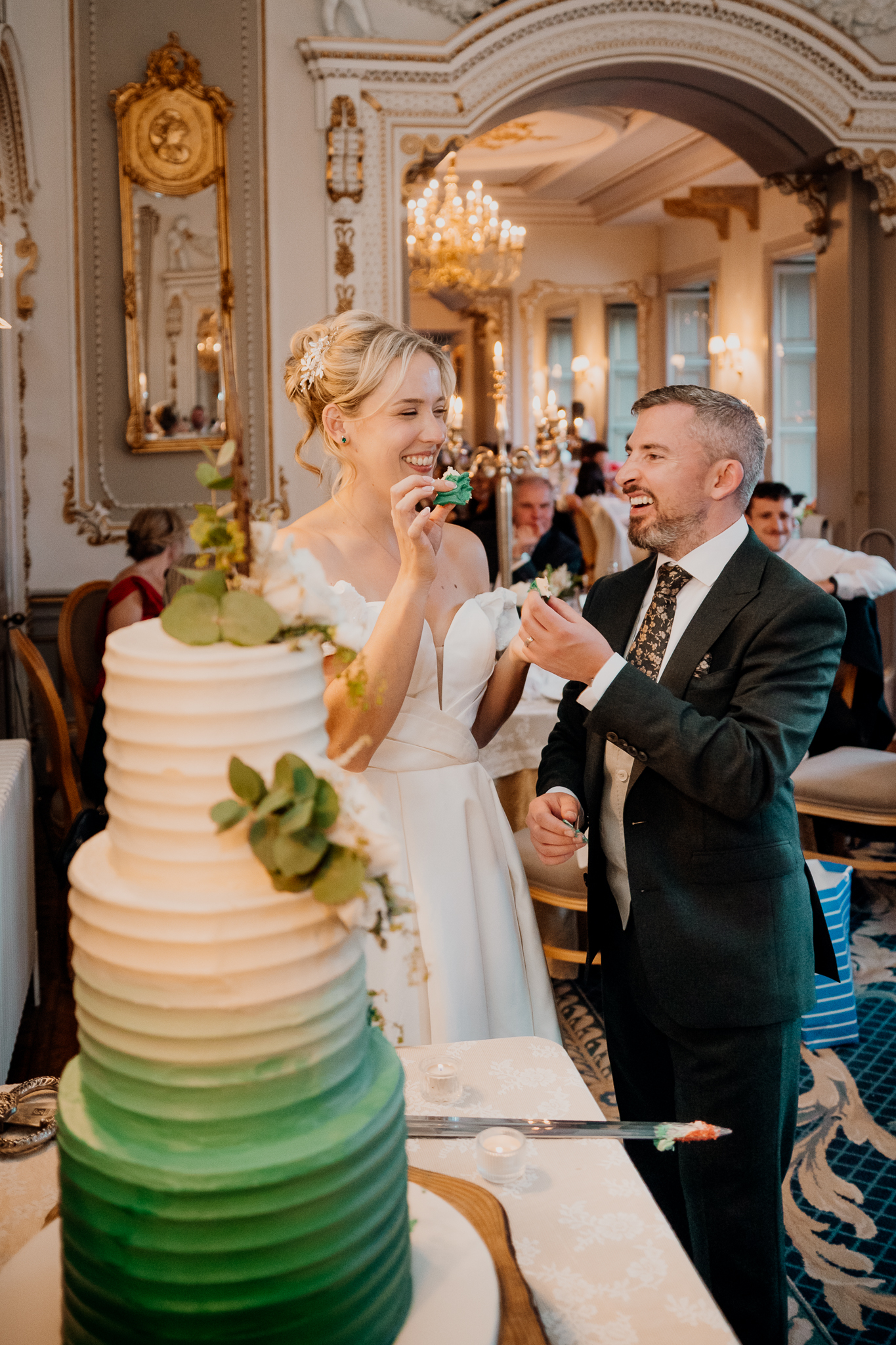 Bride Zoe and groom Mark cutting their tiered wedding cake together in the elegant Dining Room at Markree Castle, County Sligo.