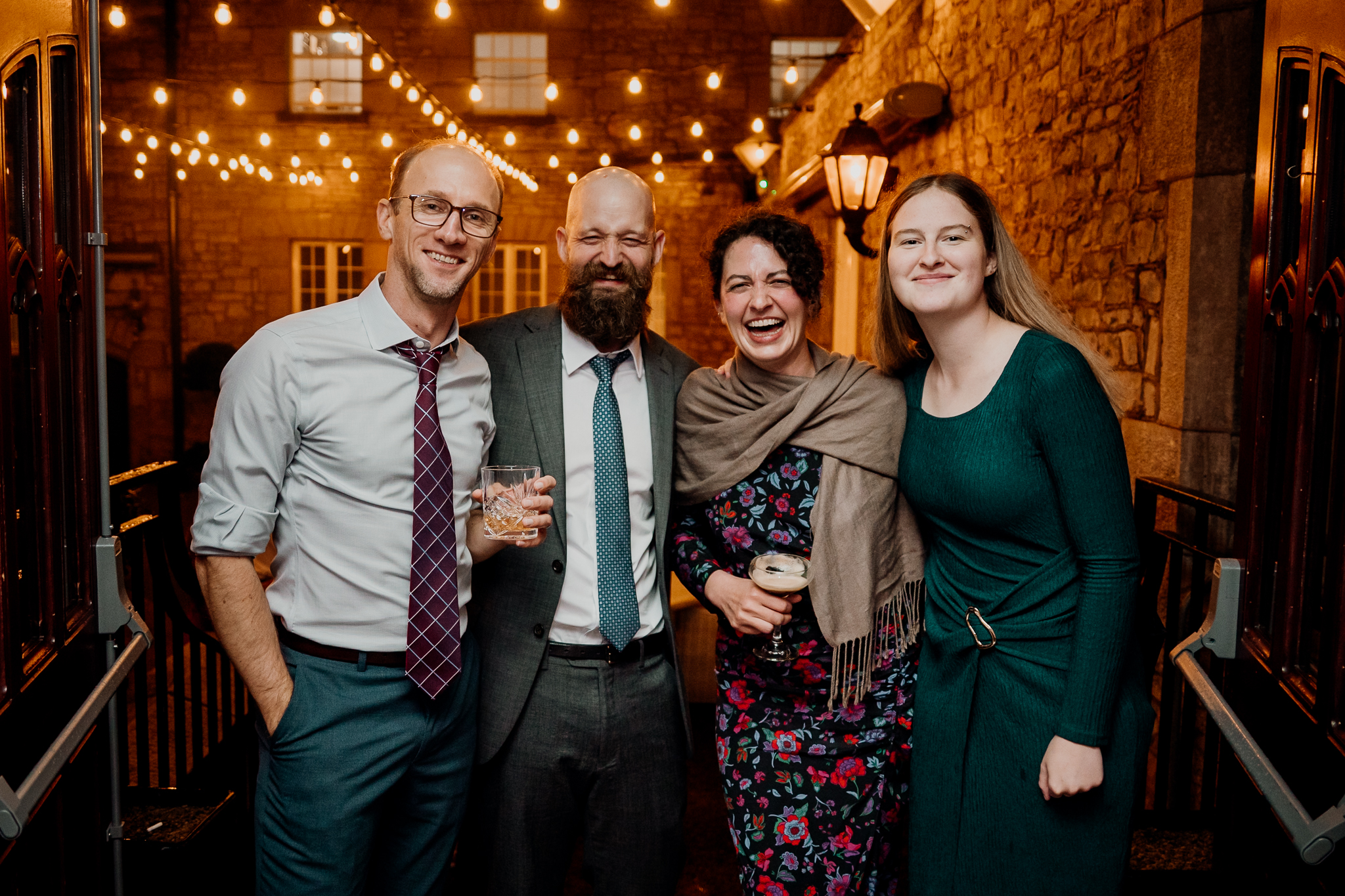 Four wedding guests posing together beneath warm evening lights at Markree Castle.