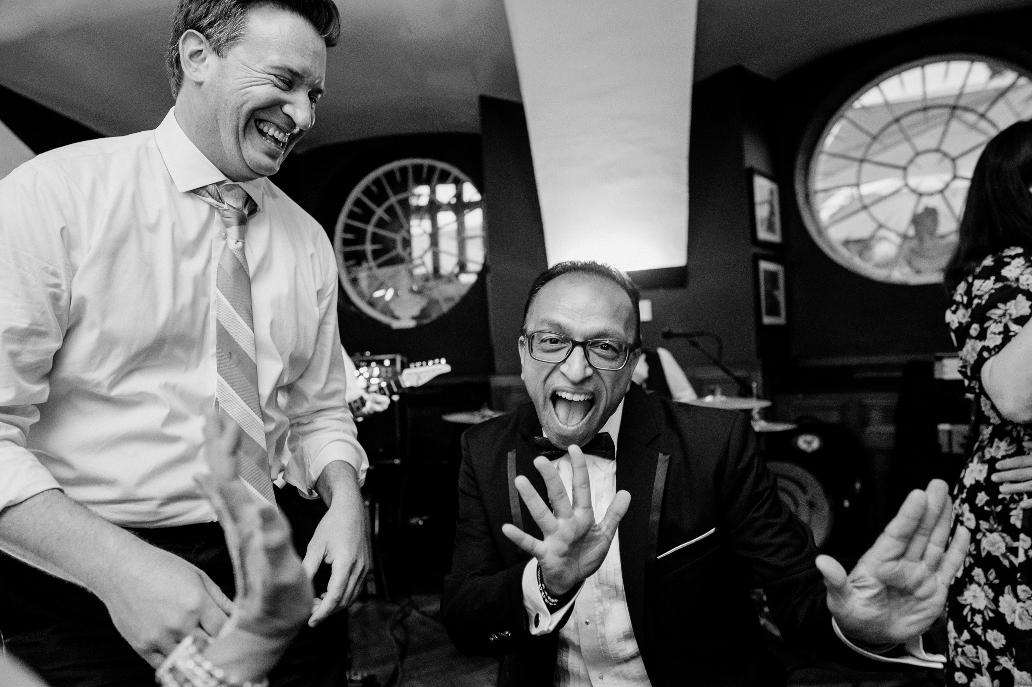 Black and white candid photograph of two male wedding guests laughing during the evening celebrations at Markree Castle.