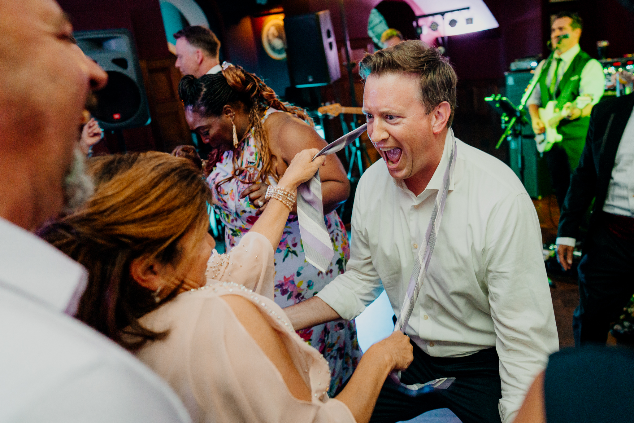 Wedding guests dancing enthusiastically and laughing on the indoor dance floor during Zoe and Mark's wedding reception at Markree Castle.