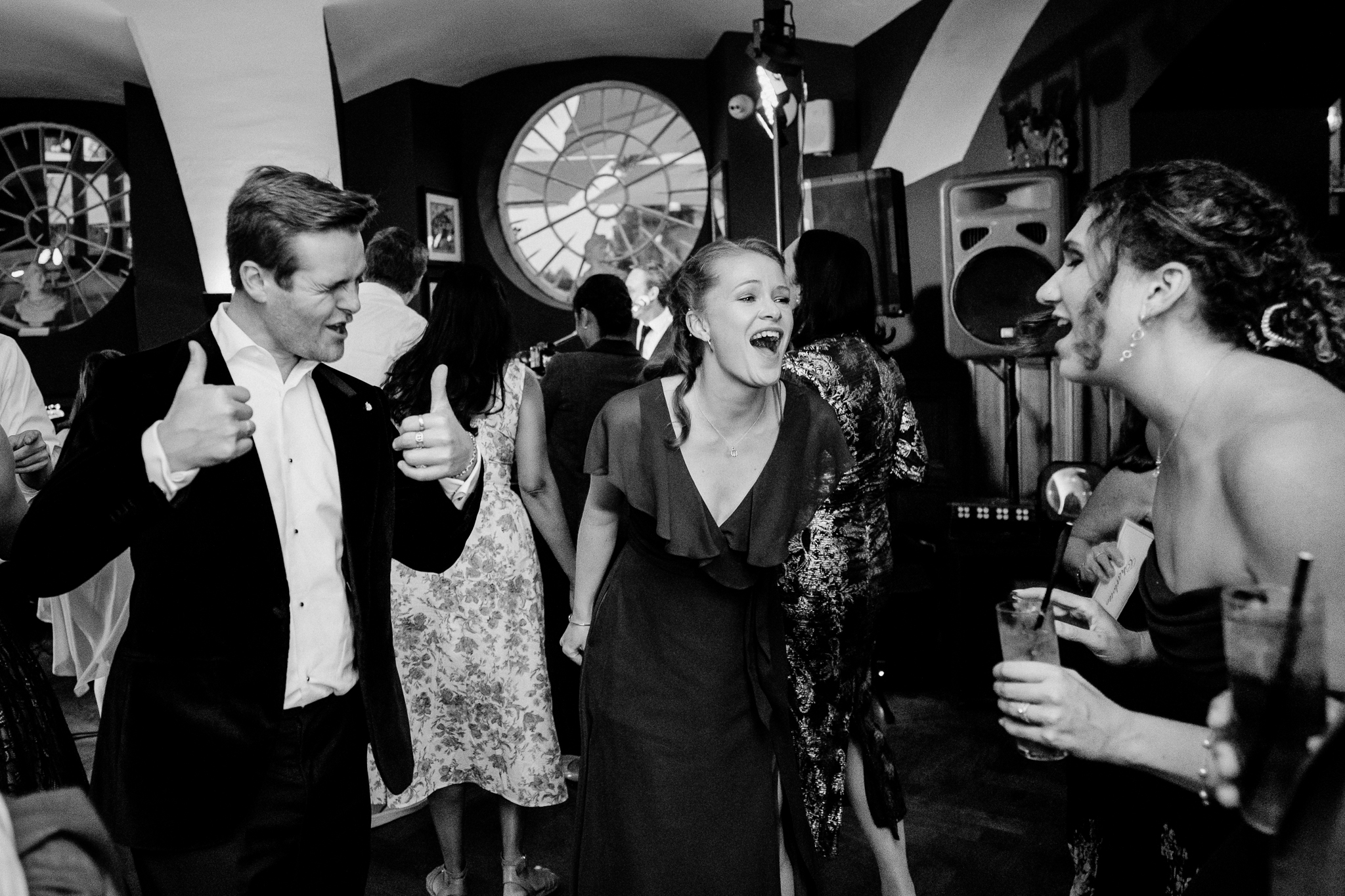 Black and white candid photograph of wedding guests laughing and enjoying the music on the dance floor at Markree Castle.