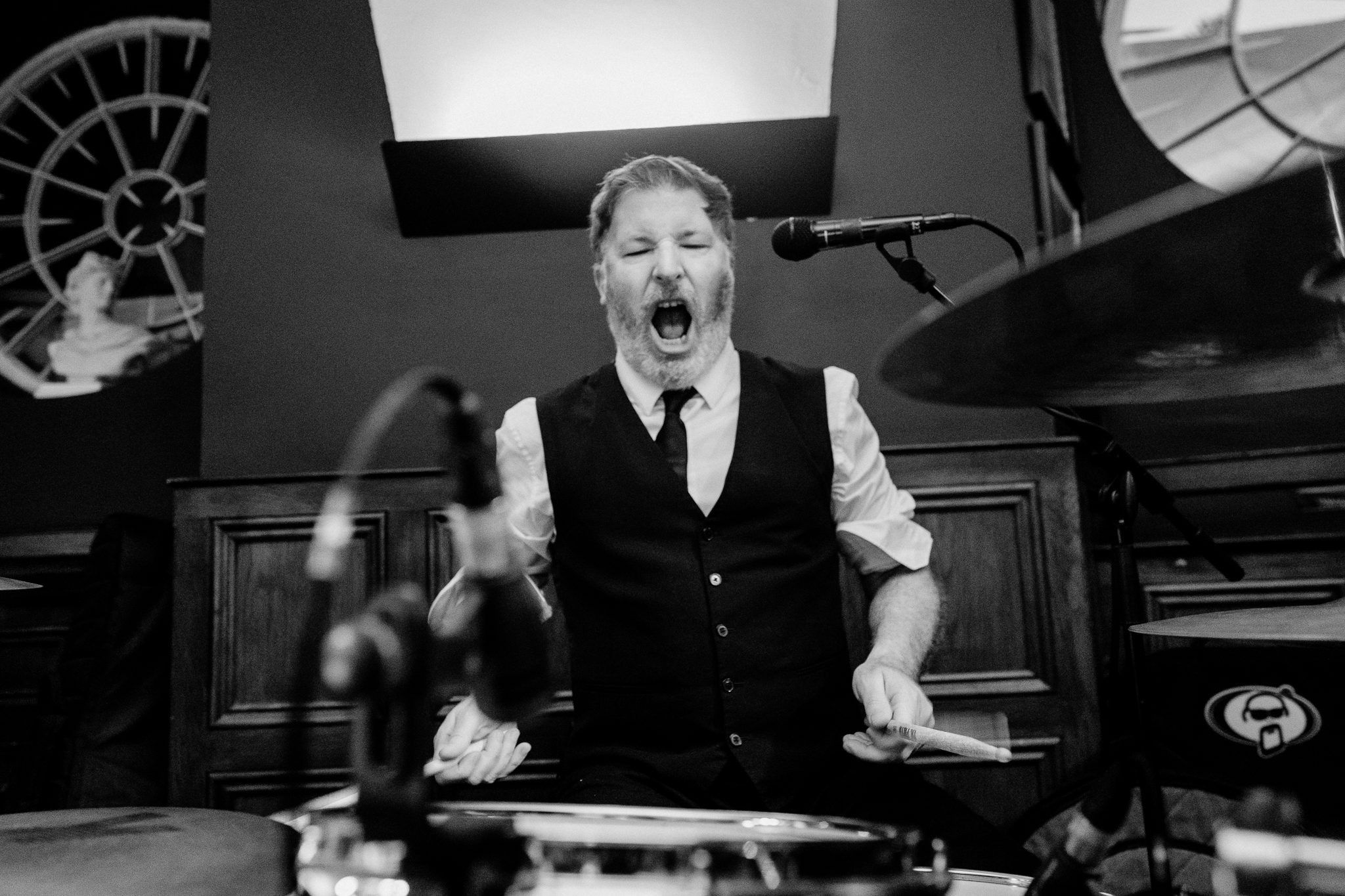 Black and white photograph of an expressive male musician performing at the drums during an evening wedding reception at Markree Castle.