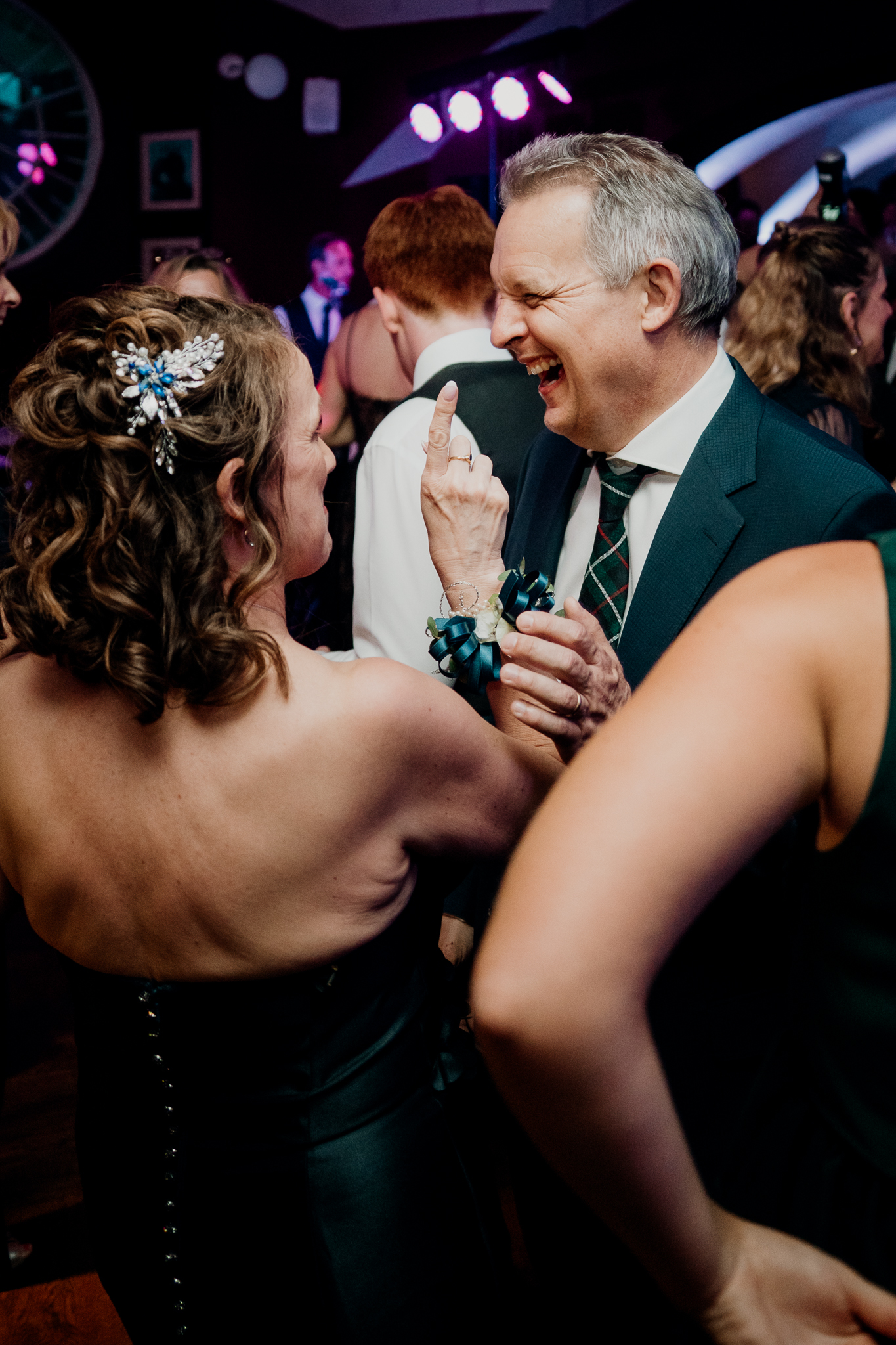 Male wedding guest smiling and holding a drink while talking with another guest on the dance floor at Markree Castle.