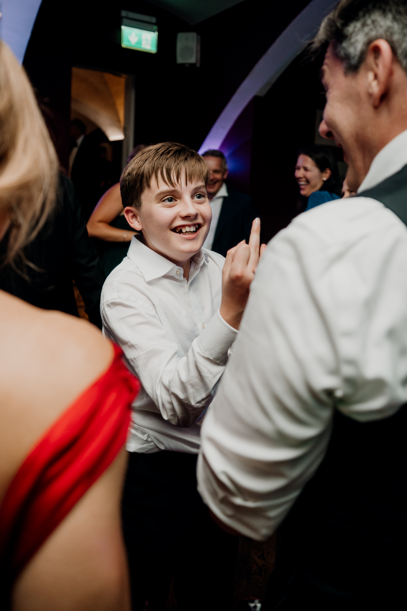 Young boy smiling excitedly among wedding guests during the evening dance floor celebrations at Markree Castle.