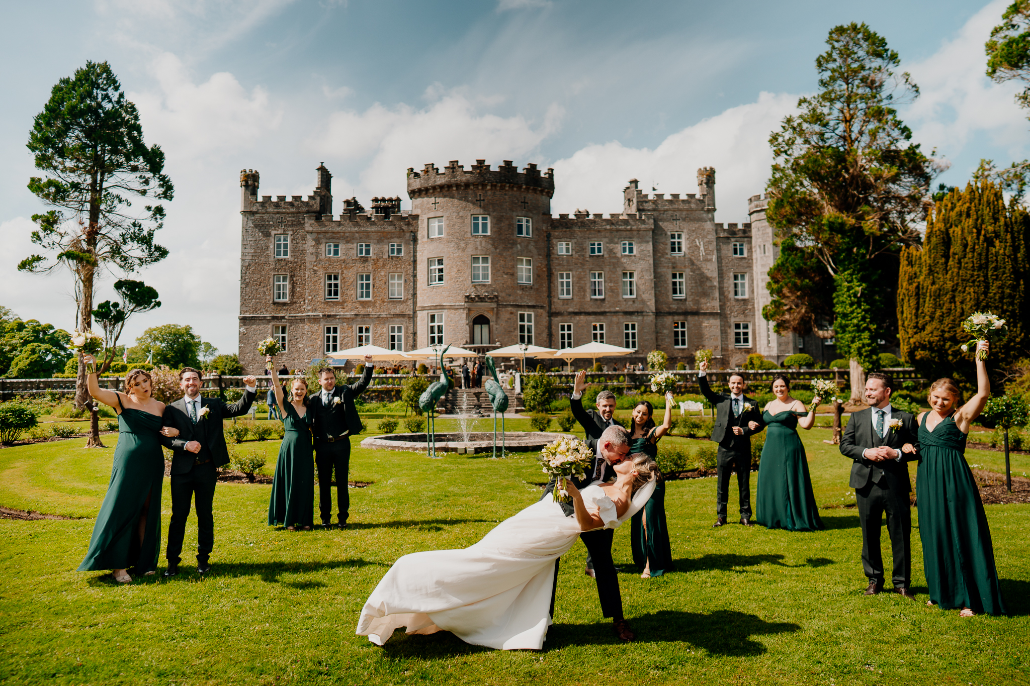 Wide wedding party photograph on the lawn with Markree Castle and its landscaped gardens in the background.