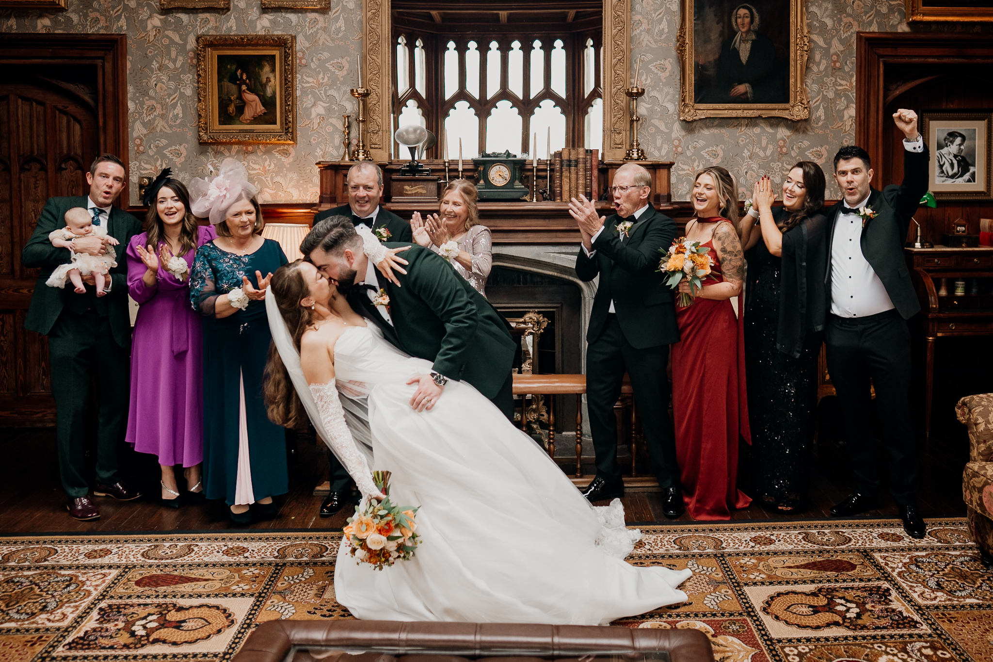Bride, groom and wedding guests posing together for a group photograph inside the historic Billiard Room at Markree Castle.