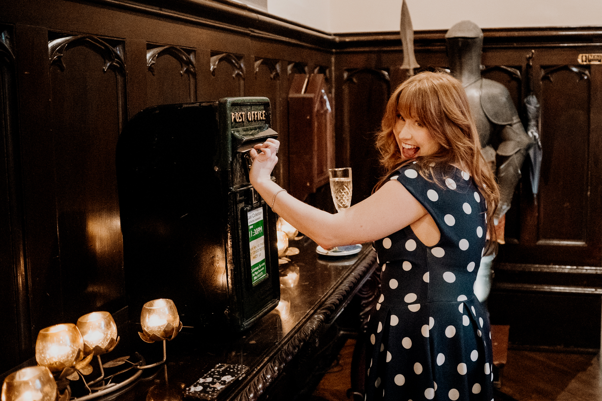 Female wedding guest holding up a drink and smiling during the reception inside Markree Castle.