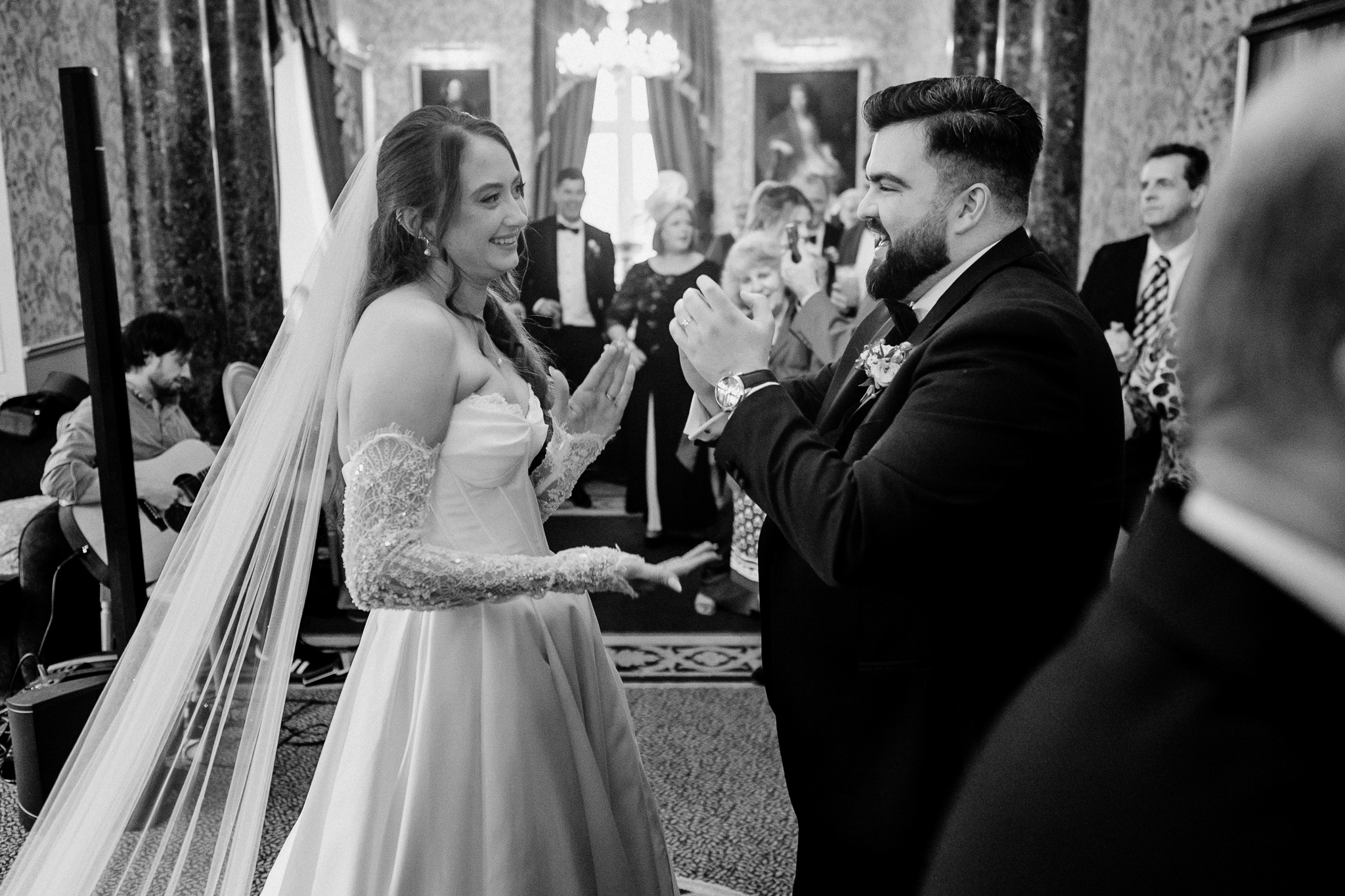 Black and white candid photograph of wedding guests greeting each other during the reception at Markree Castle.